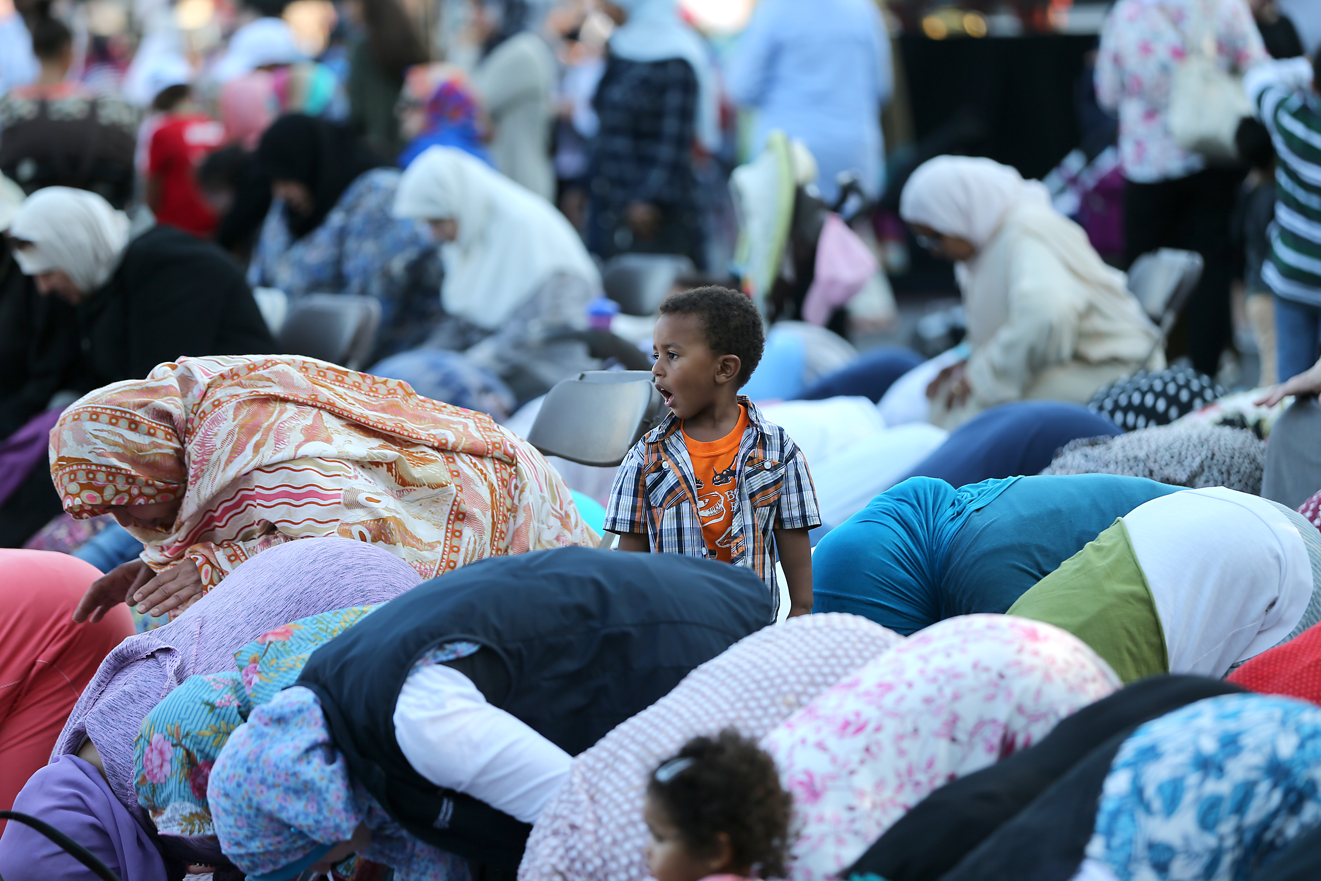 Mohammad Oubaha, 3, watched as his grandmother prayed at the festival.