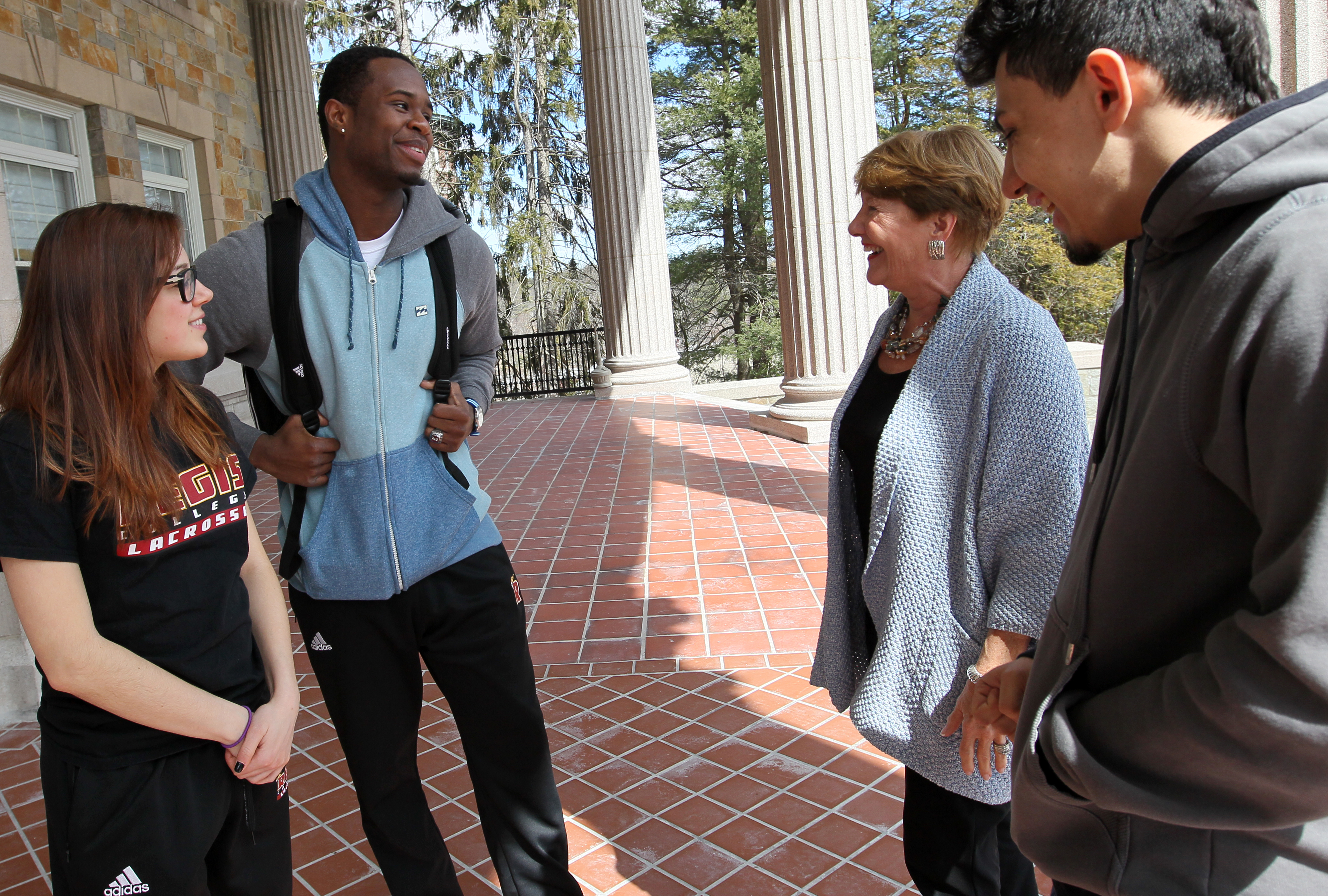 Regis College president Antoinette Hays (second from right) talked with students last month. From left: Julia Jones, Sam Jean-Gilles, and Chris Cortez, of Framingham.