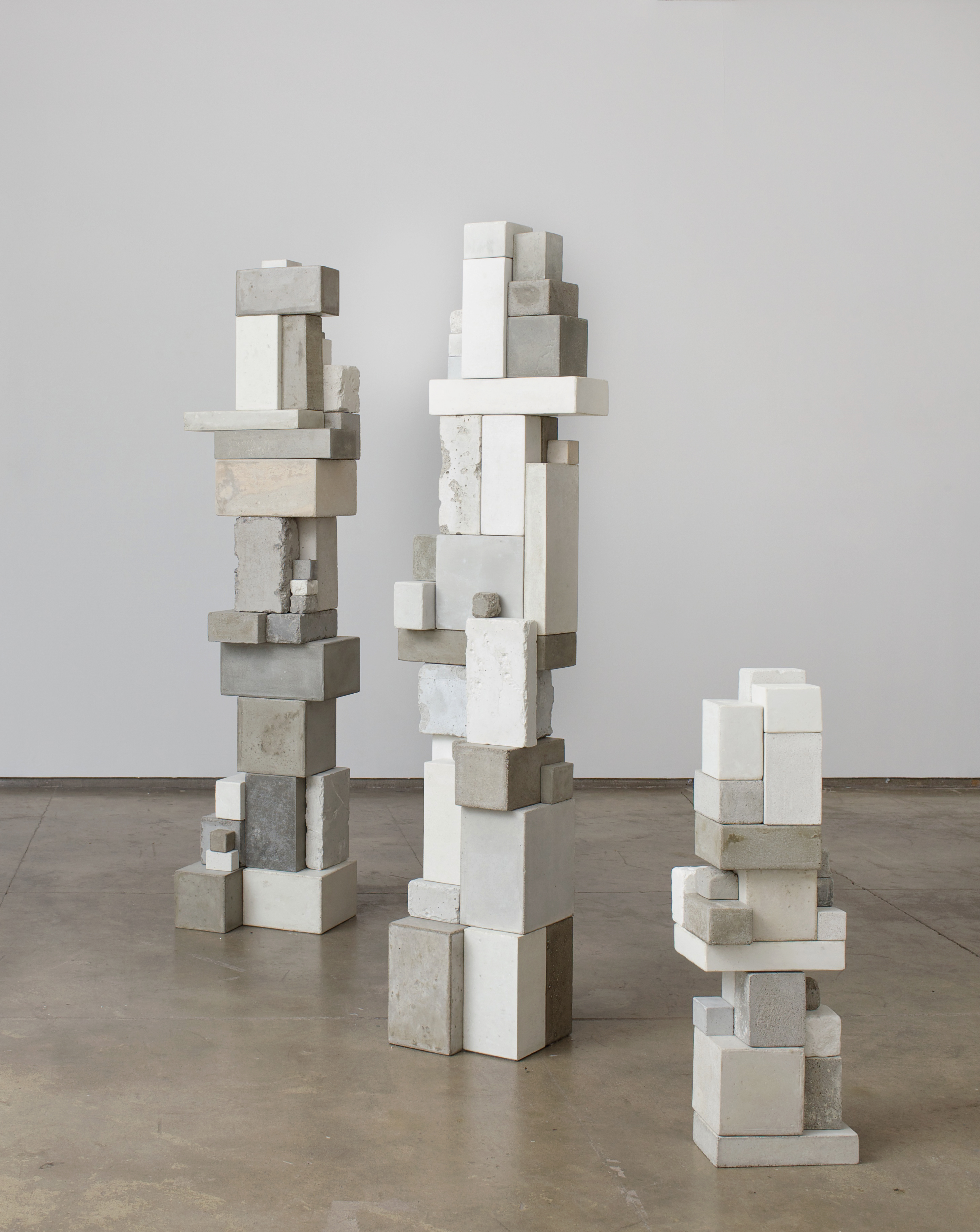 “Surrogate (JS), Surrogate (KRL), Surrogate (ARL)” (2012) is made of cement, mica, and clock movements.