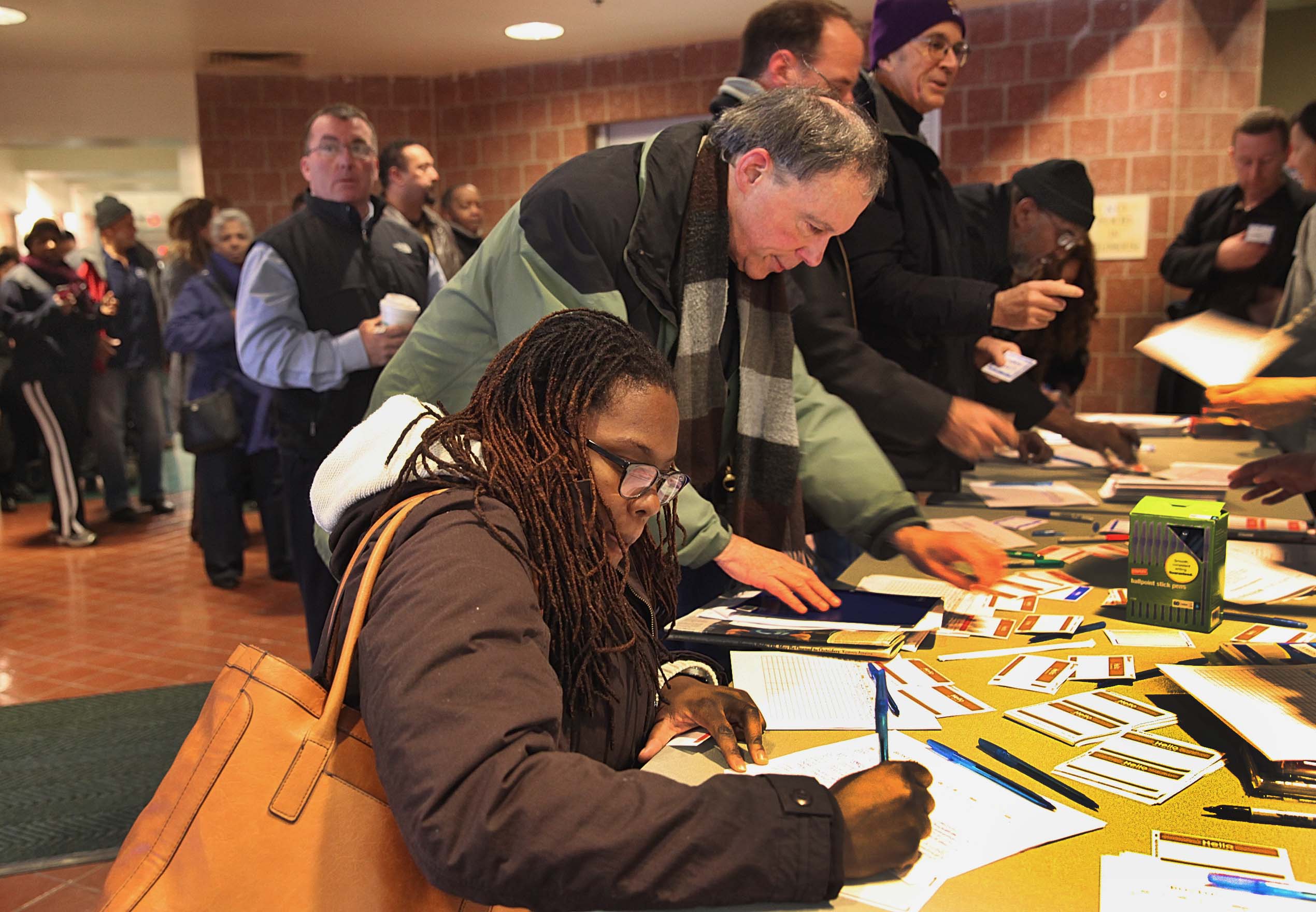 Sydney Janey of Roxbury, left, and others registered to attend a a town meeting with Mayor-elect Martin J. Walsh at the Reggie Lewis Track and Athletic Center in Roxbury on Saturday.