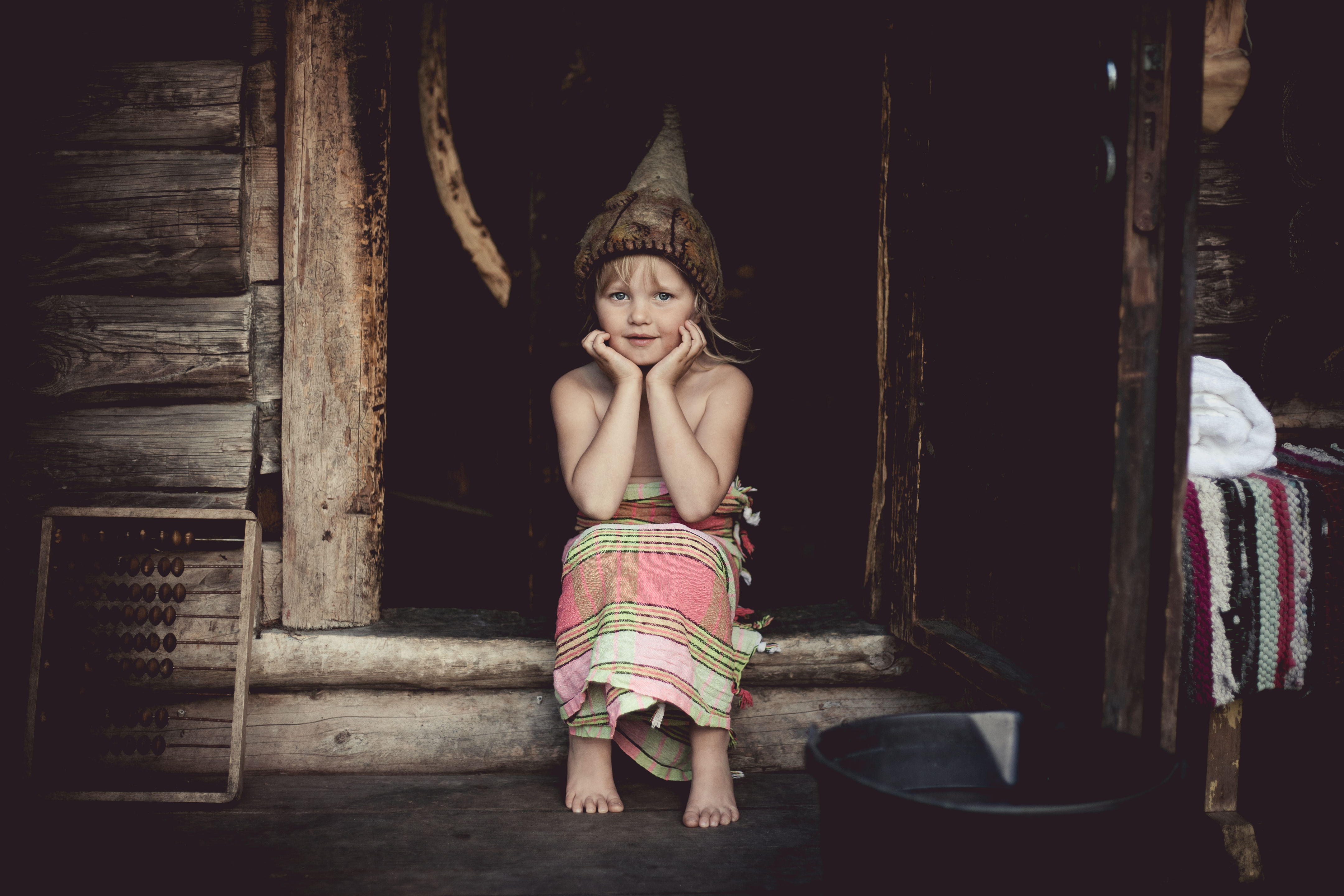 A child wearing traditional garb in a sauna.