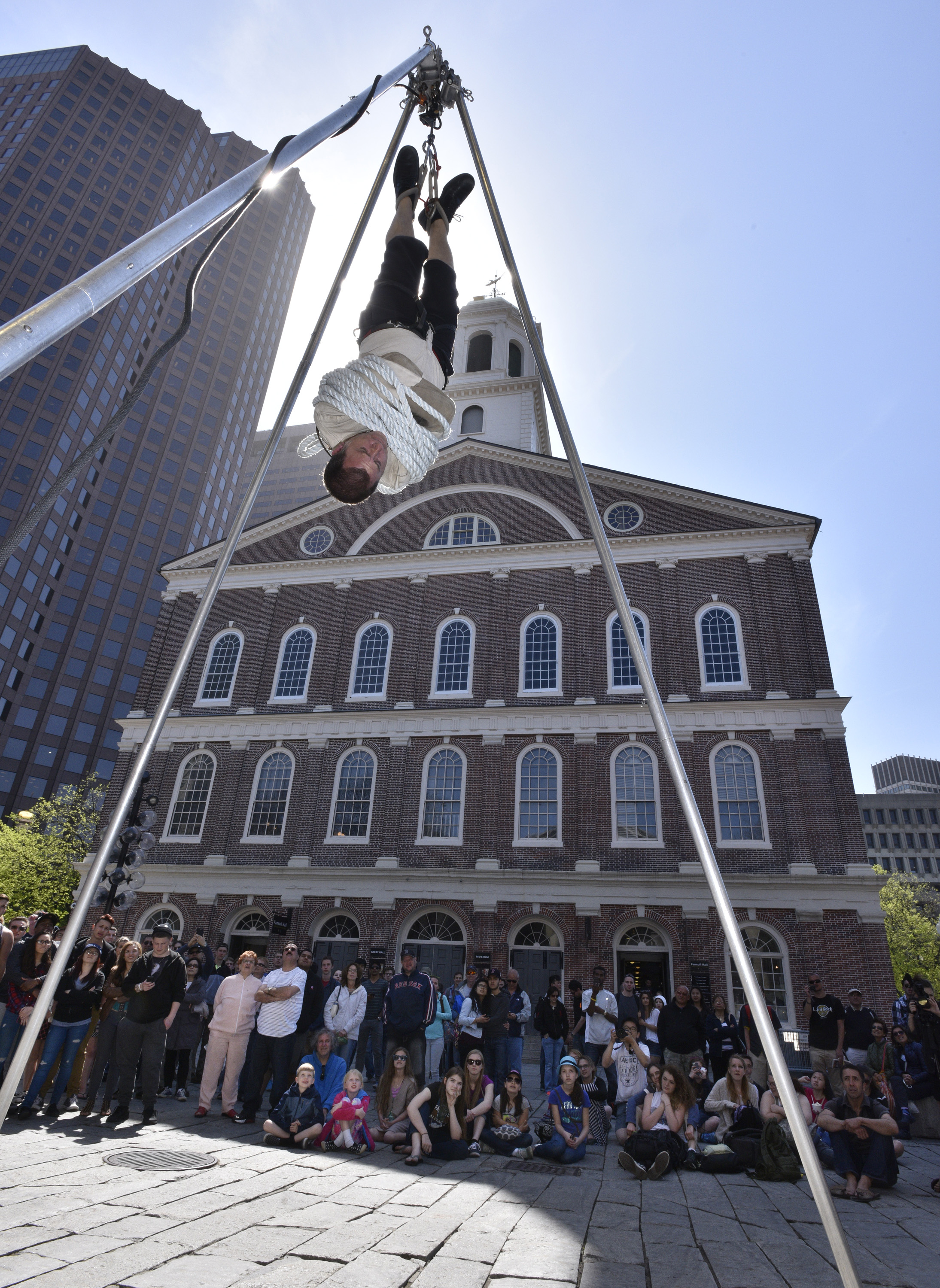 Performer "Jason Escape" freed himself from a straight jacket while hanging by his feet outside of Faneuil Hall.