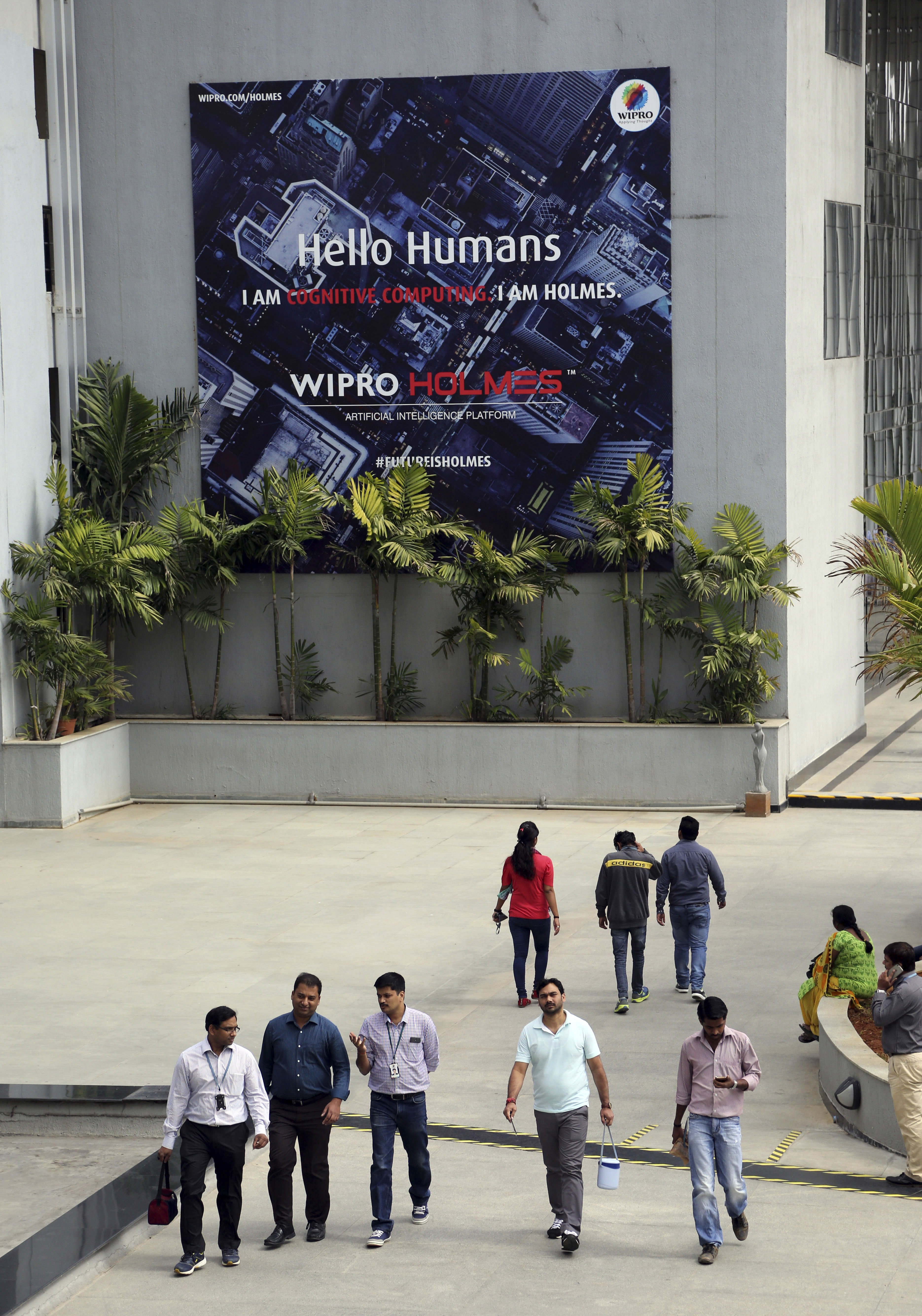 Wipro Ltd. employees walked inside the company’s compound during a break at their headquarters in Bangalore, India. Proposed US legislation would require salaries for H-1B visa holders to be doubled to make it harder for companies to replace American workers with those from countries like India.