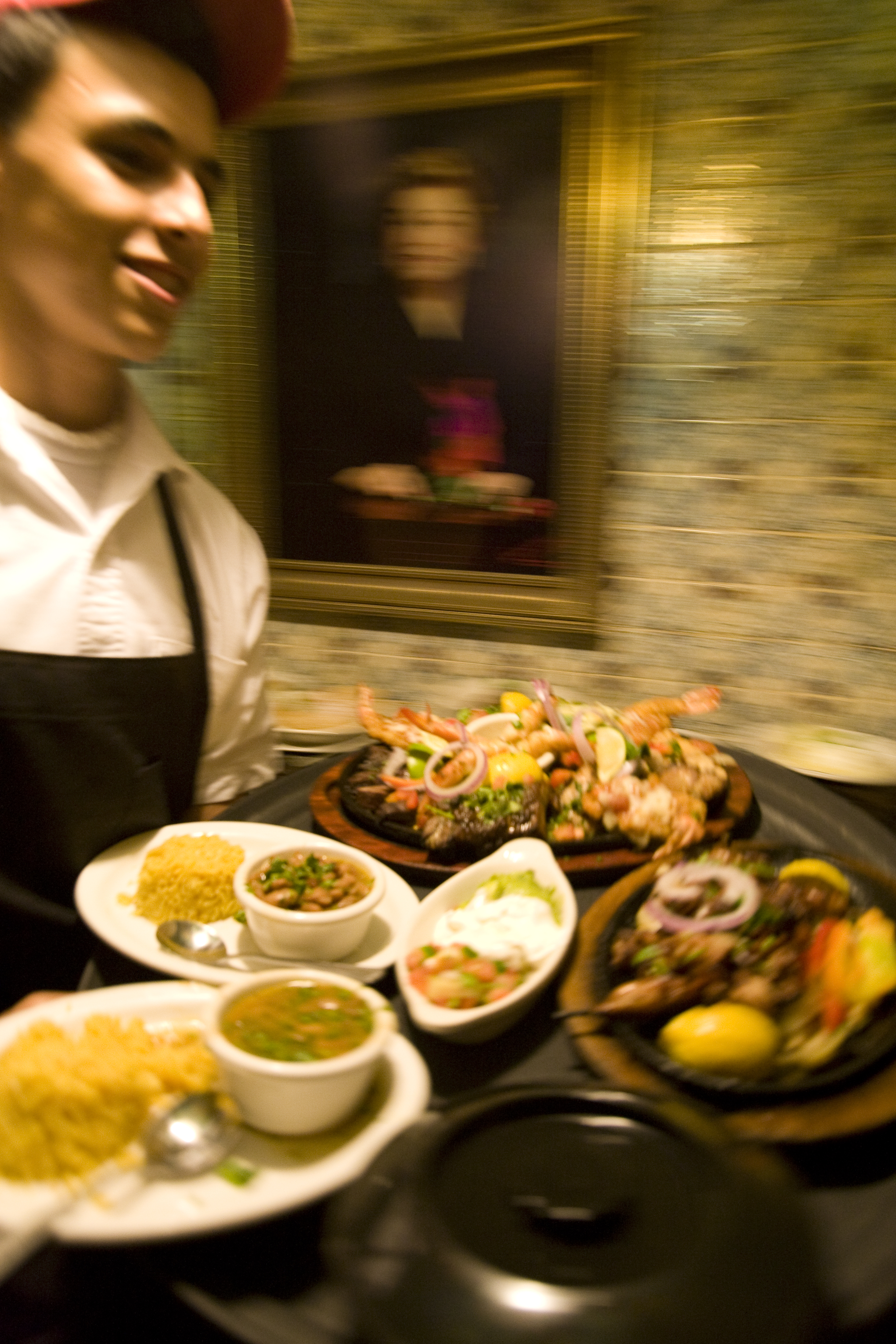 A server speeds past a portrait of Mama Ninfa at the original Ninfa’s on Navigation.