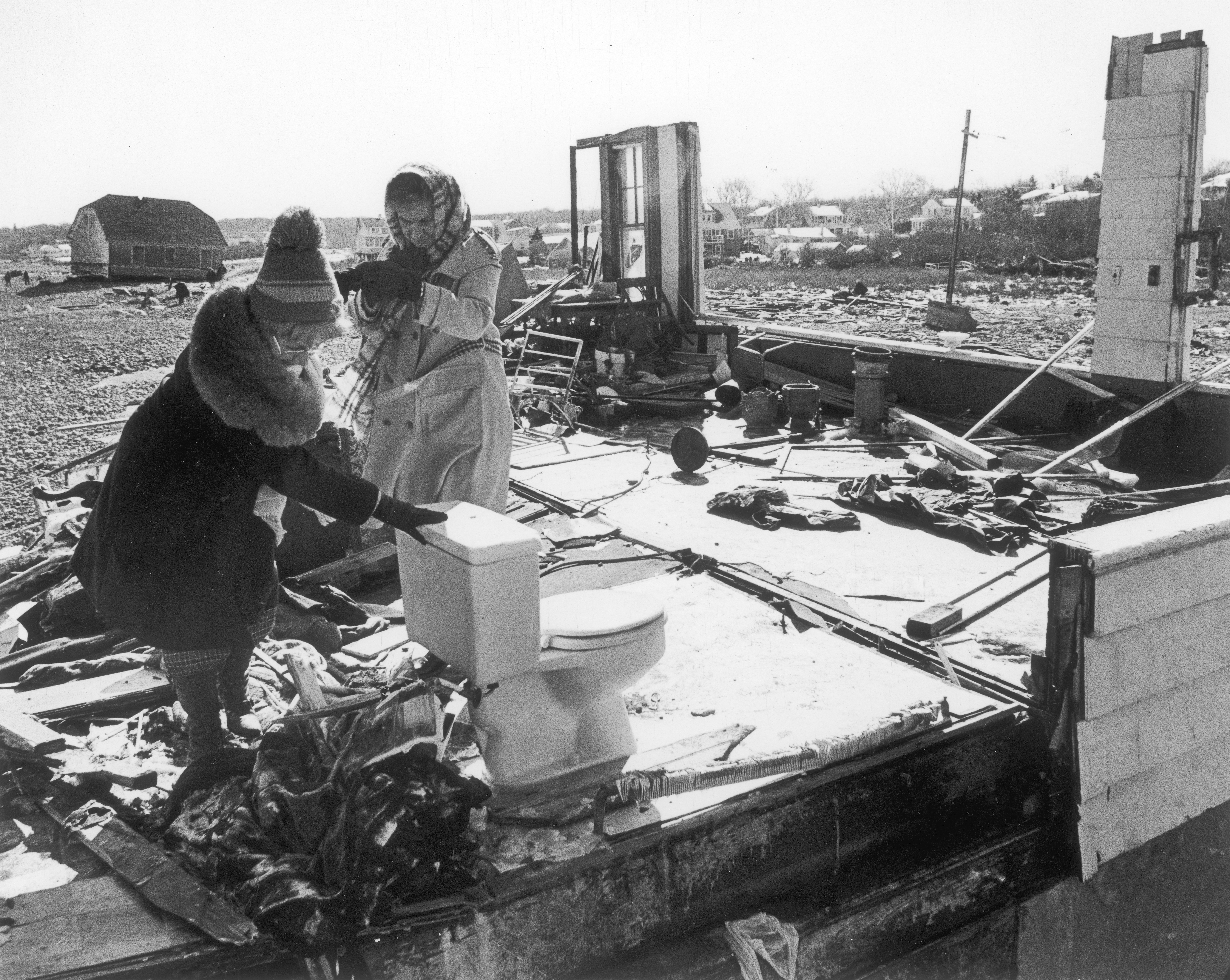 Mrs. Joseph Conley leaned on the only remaining fixture in her destroyed house in Scituate as she left with Mrs. Edward Dailey, who she was staying with.
