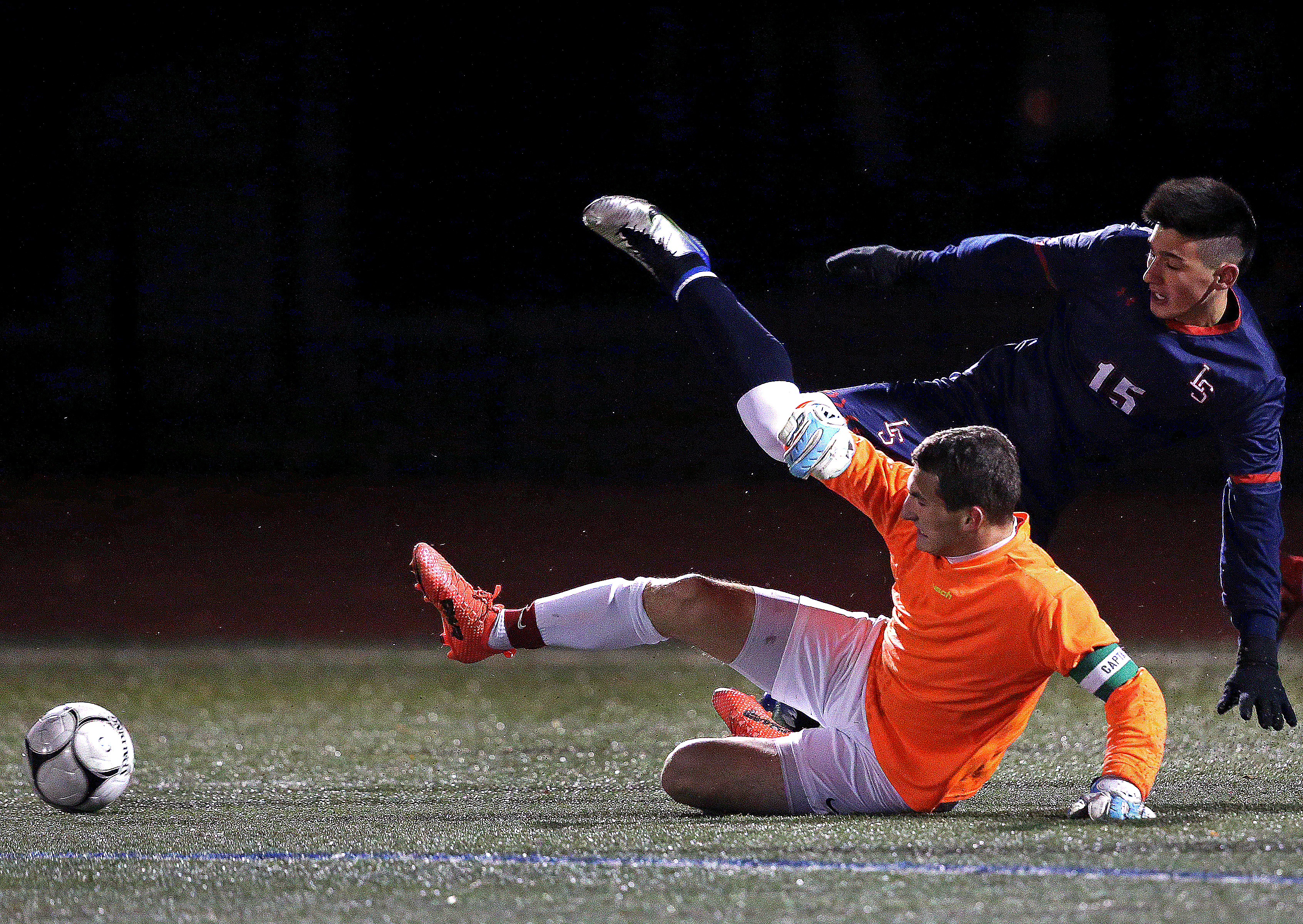 Wellesley keeper Anders Pineau (1) breaks up a rush by Lincoln-Sudbury's Joseph Akisik (15).