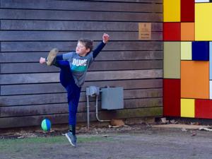 A young boy kicked a football at Discovery Green in downtown Houston.