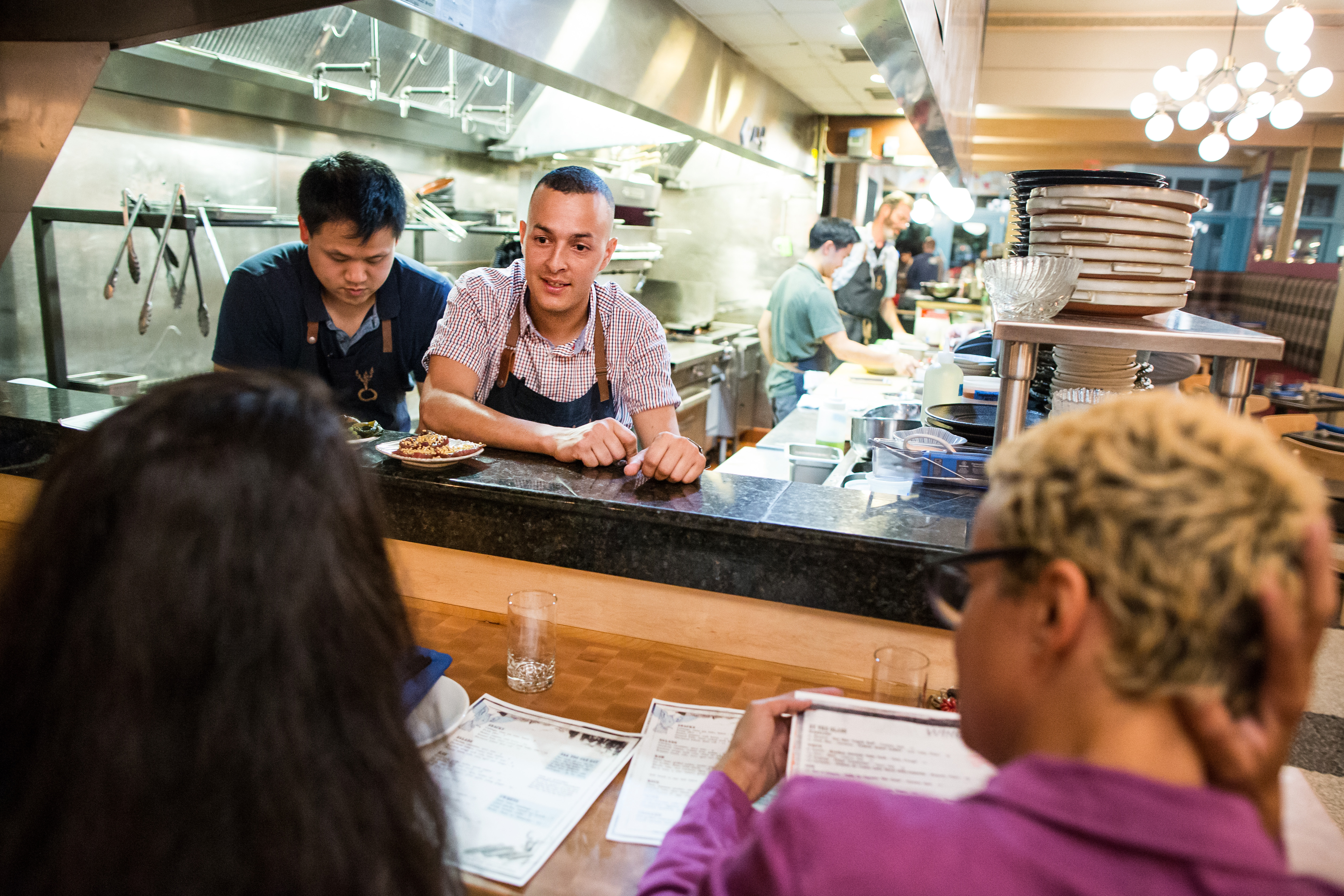 Sous chef Yesid Areiza spoke with customers from the open kitchen at Whaling in Oklahoma in the South End.