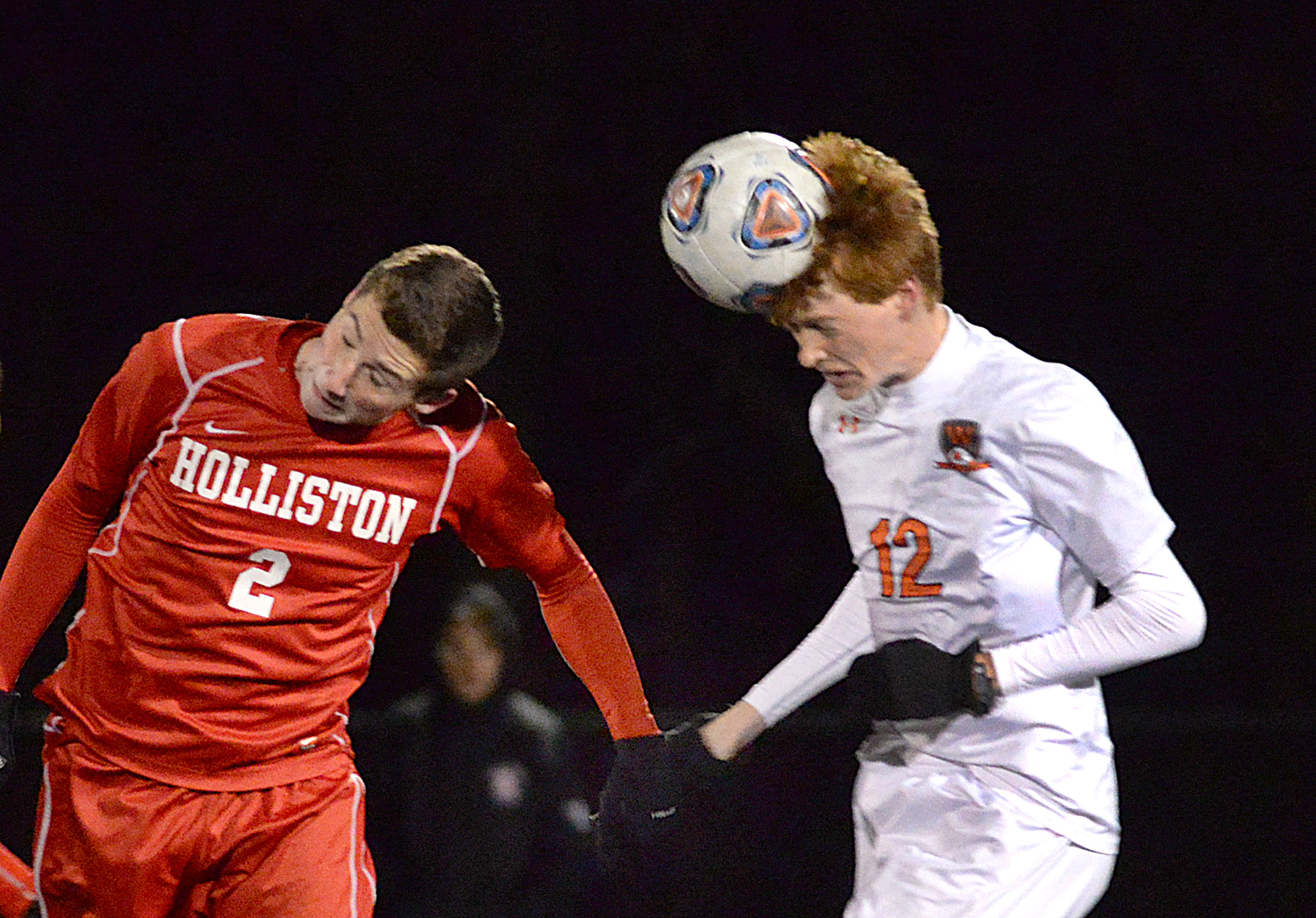 Wayland’s Gage Fuller (12) heads the ball past Holliston’s Jonny Paecht in the Div. 3 semifinals at Norwell.