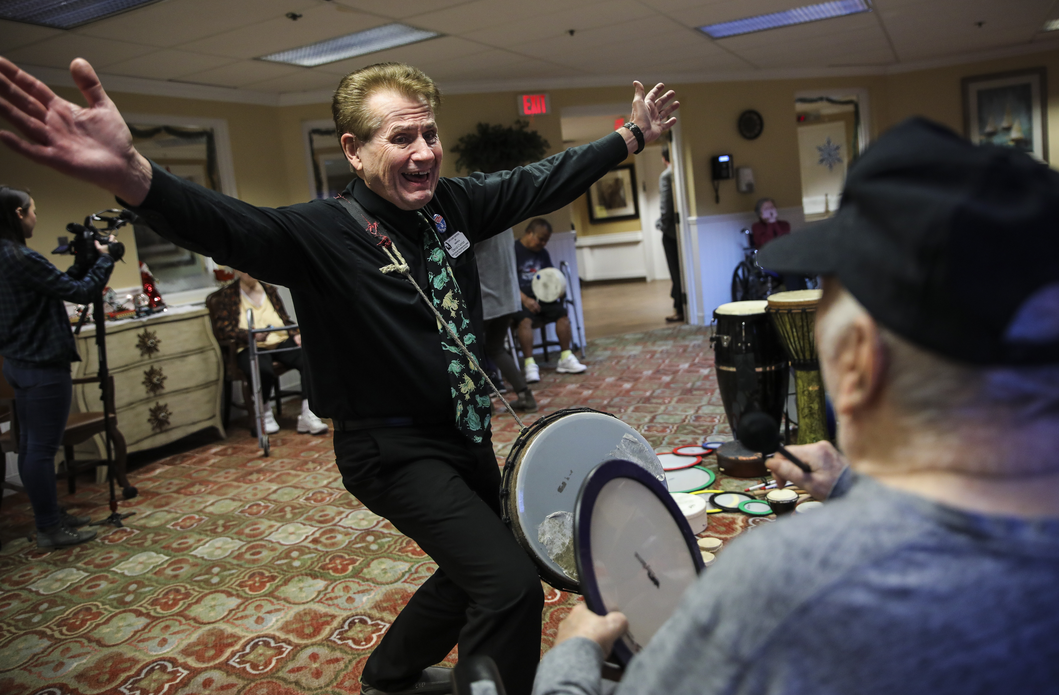 David Currier spread his arms wide while singing Christmas carols in a “drum circle” with patients at Life Care Center of the North Shore in Lynn.
