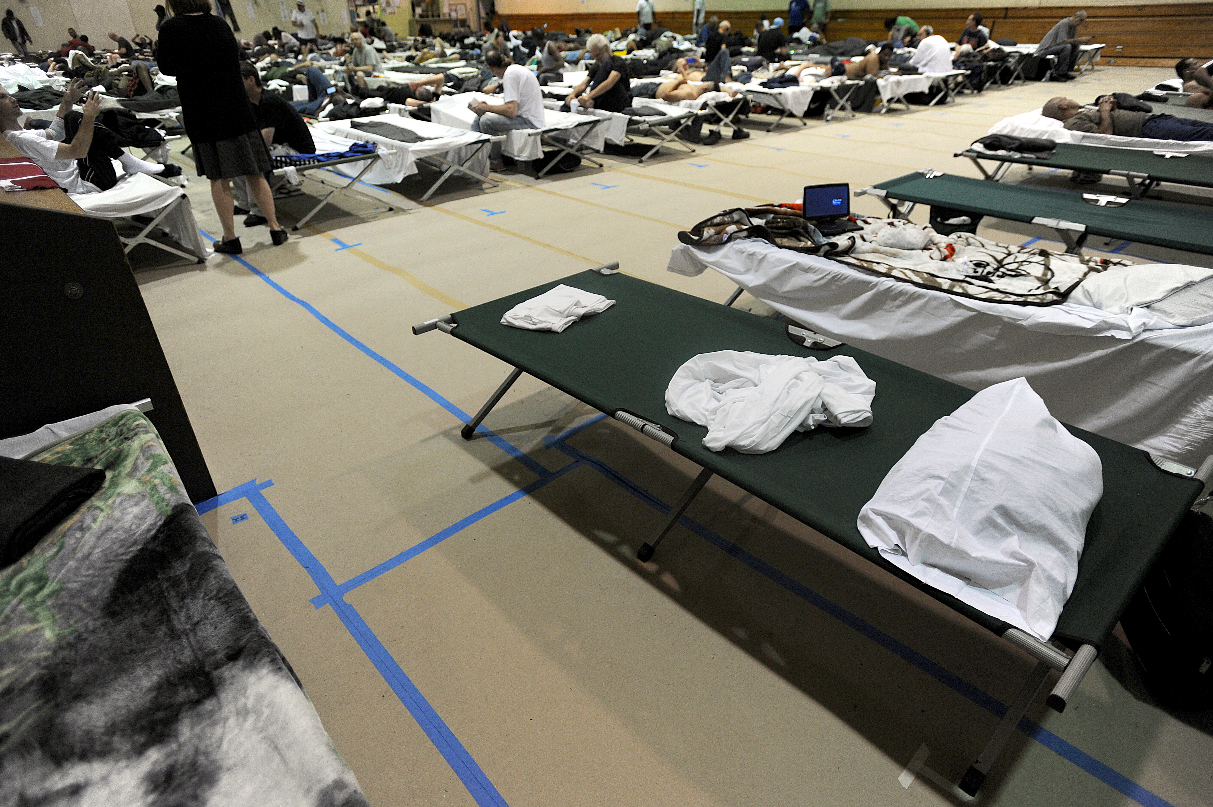 Cots lined the basketball court at the South End Fitness Center, a temporary shelter for former Long Island residents.