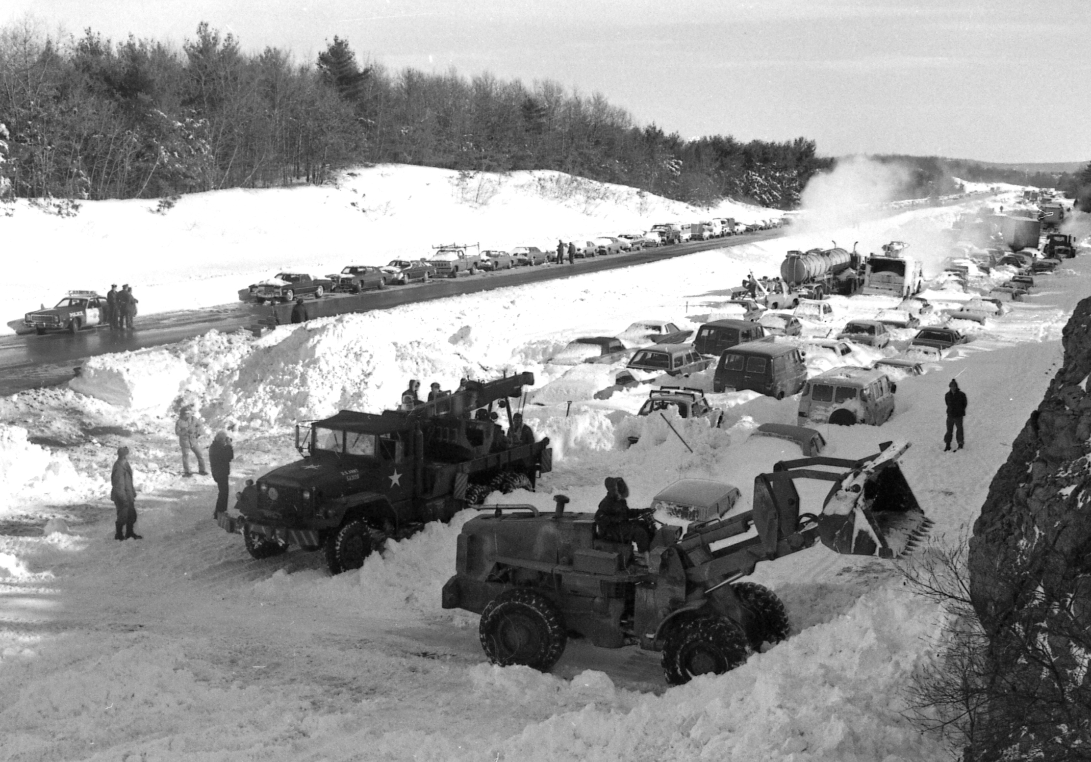 Military equipment cleared snow from the southbound lane of Route 128 between Highland Avenue and Great Plain Avenue in Needham on Feb. 9, 1978. Vehicles already pulled from the snow lined the northbound lane.