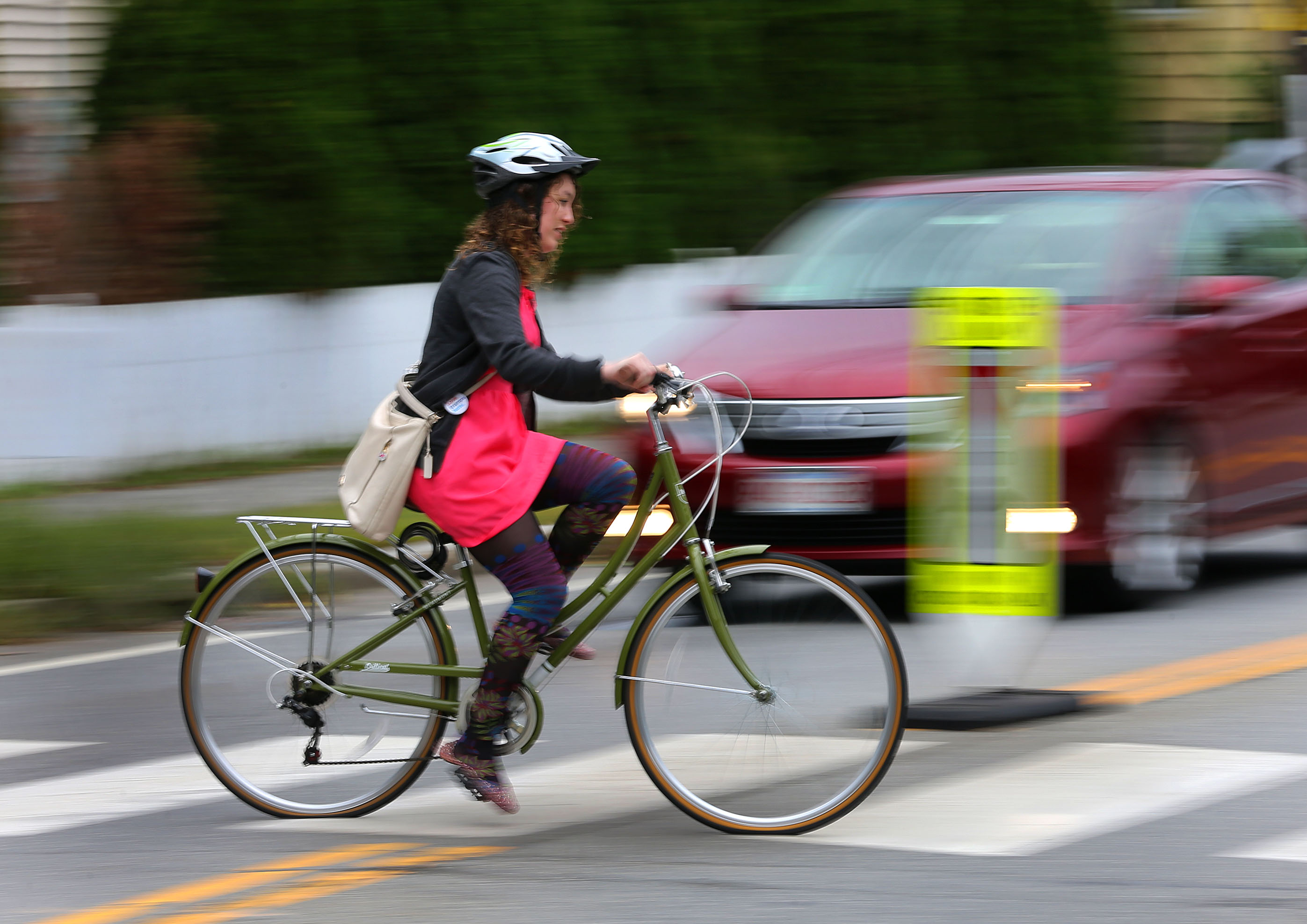 A bicyclist crossed Lake Street on the crosswalk while biking along the MInuteman Bike Trail.
