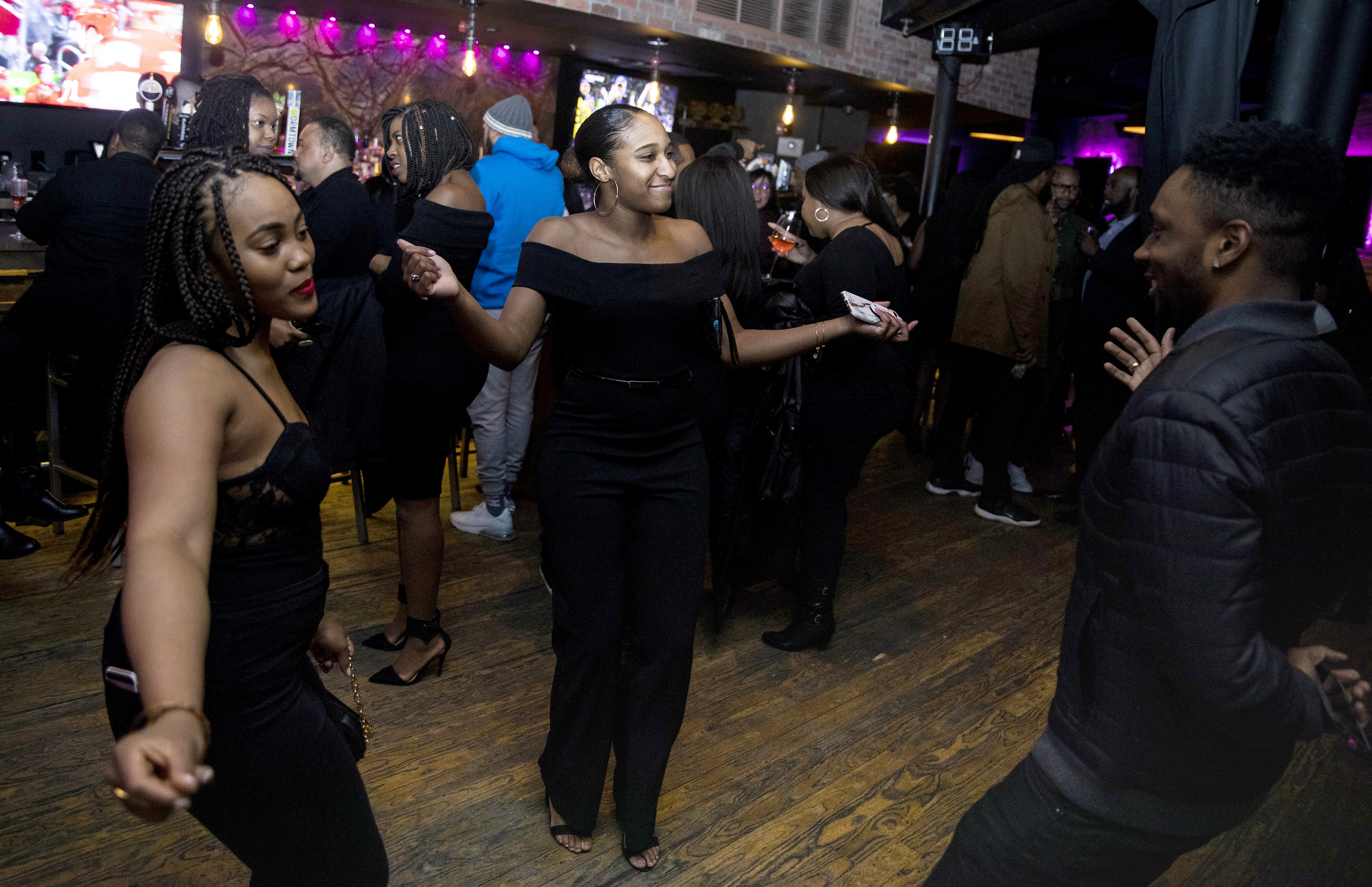 Philomena Nwanze (left) Jamon Patterson (center) and Philip Washington danced at the Toast to Black Excellence at 2Twenty2 Lounge.