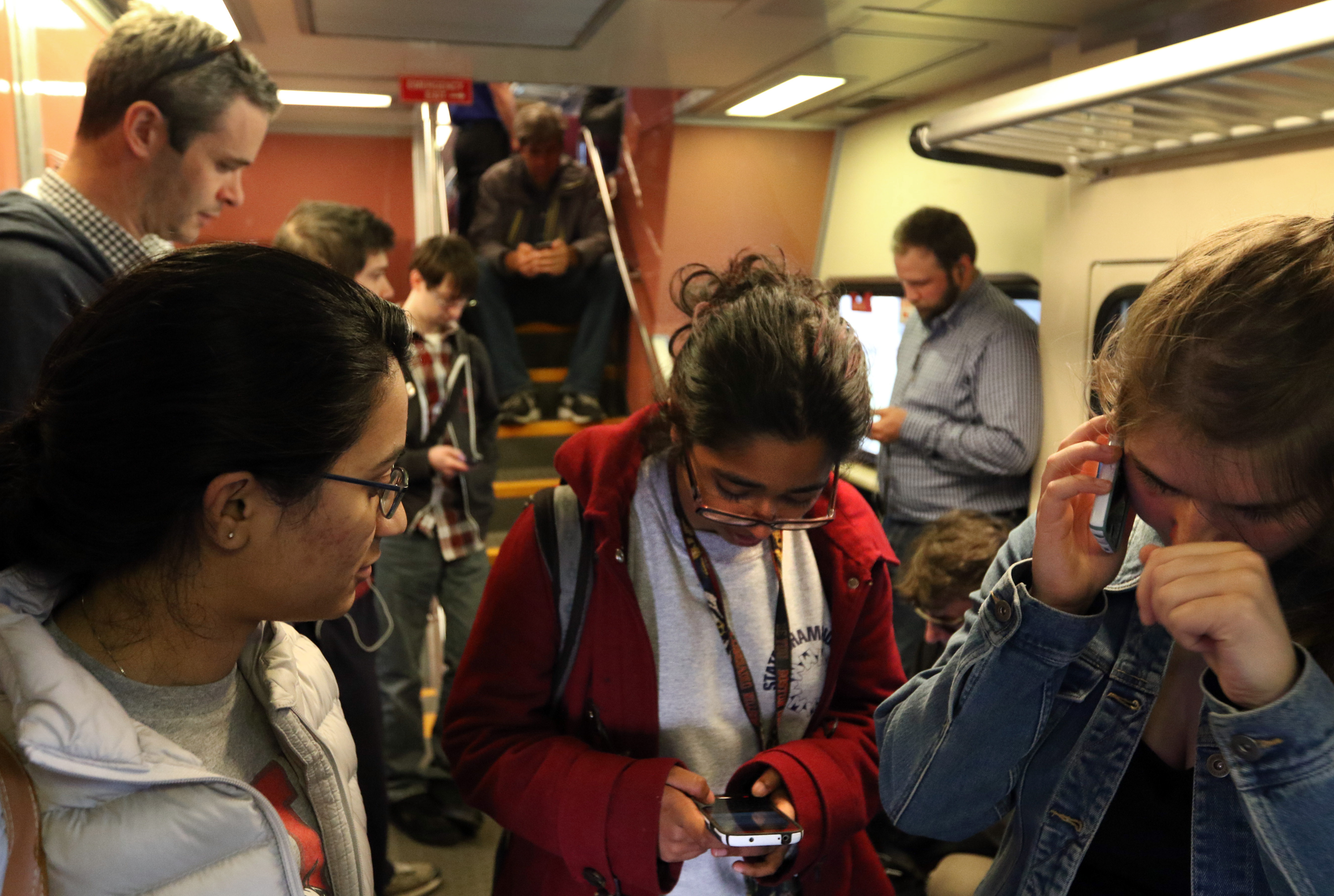 Boston University students Premsai Nagabhrava (left), Raji Pyda (middle), and Alanna Cote on a commuter rail train in Boston.
