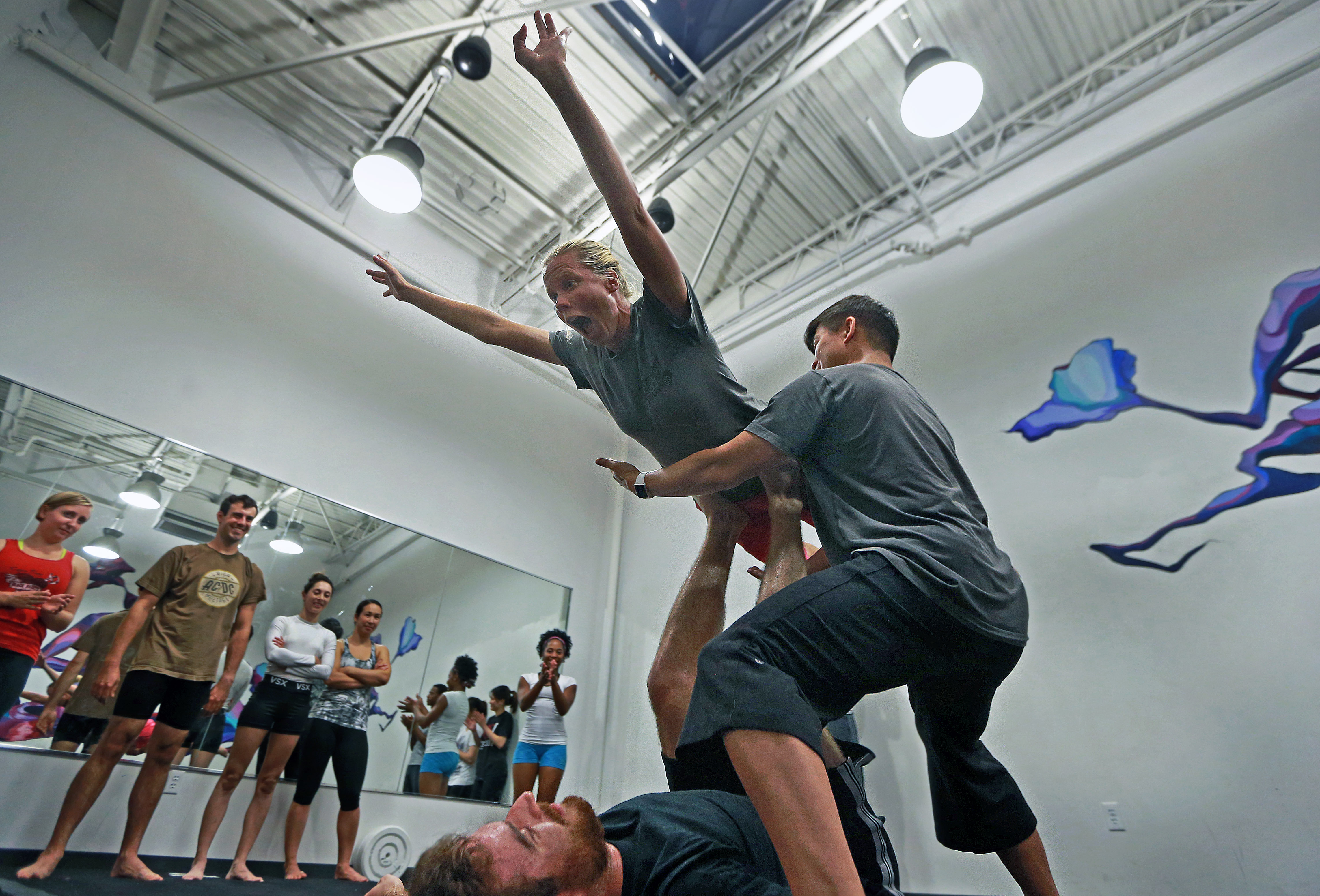 Petra Rood gets an assist from instructors while doing AcroYoga in Somerville.
