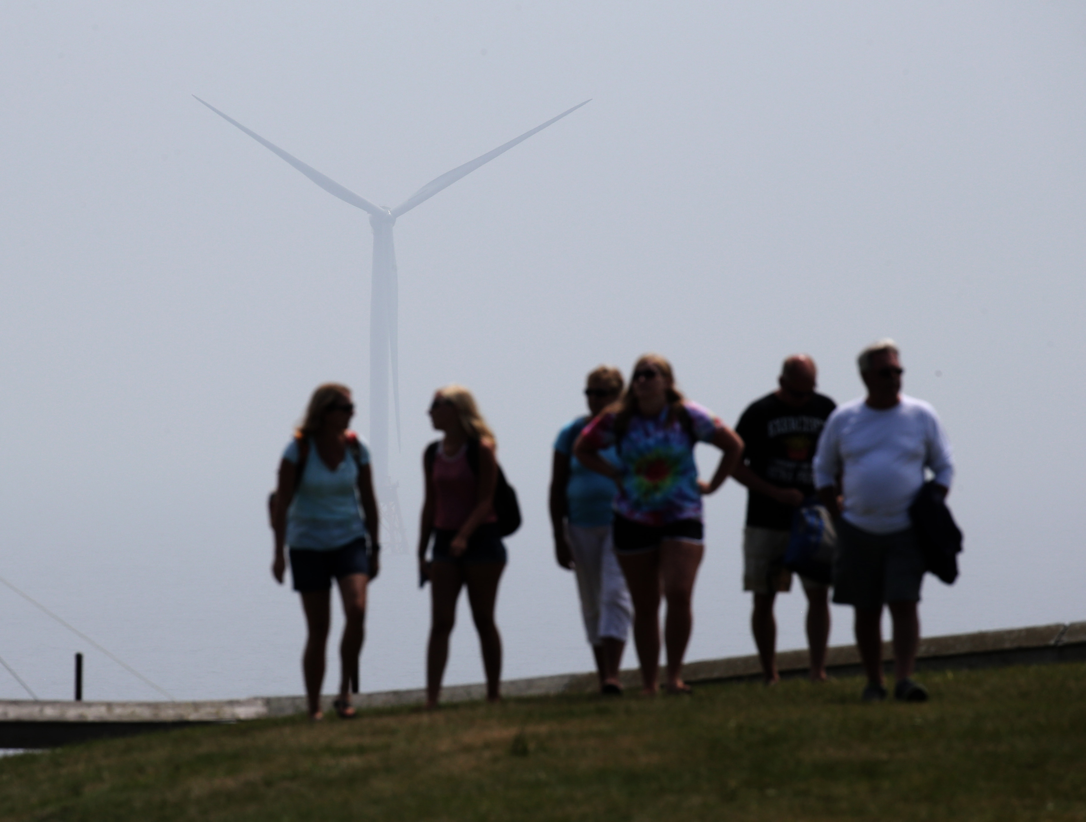 A massive offshore turbine behind them, tourists strolled on Block Island last week. Island residents have had to rely on smog-producing diesel generators for their power.