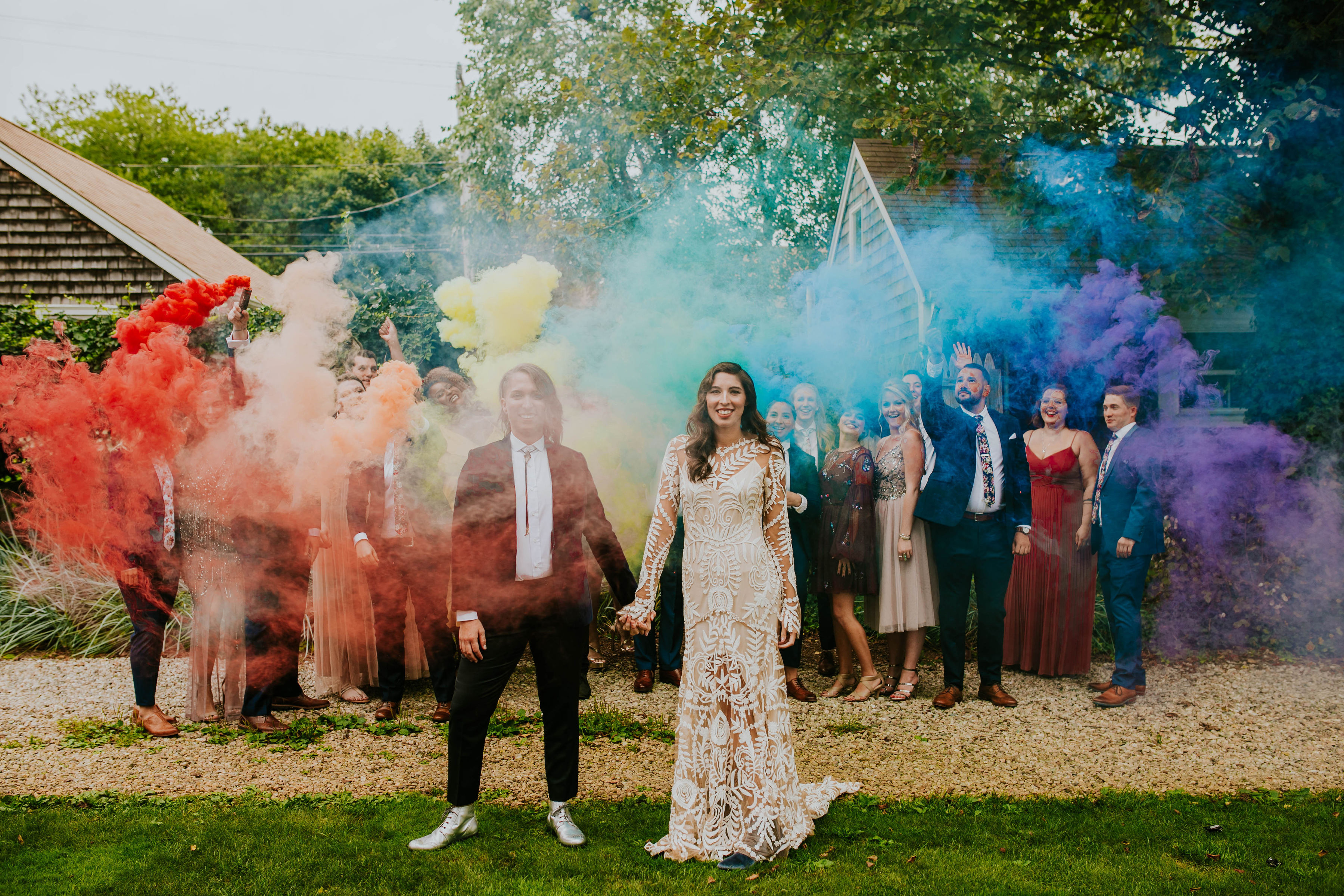 Jess Mooney and Katy DeMoura declare their pride in front of an installation of rainbow-colored smoke before tying the knot.