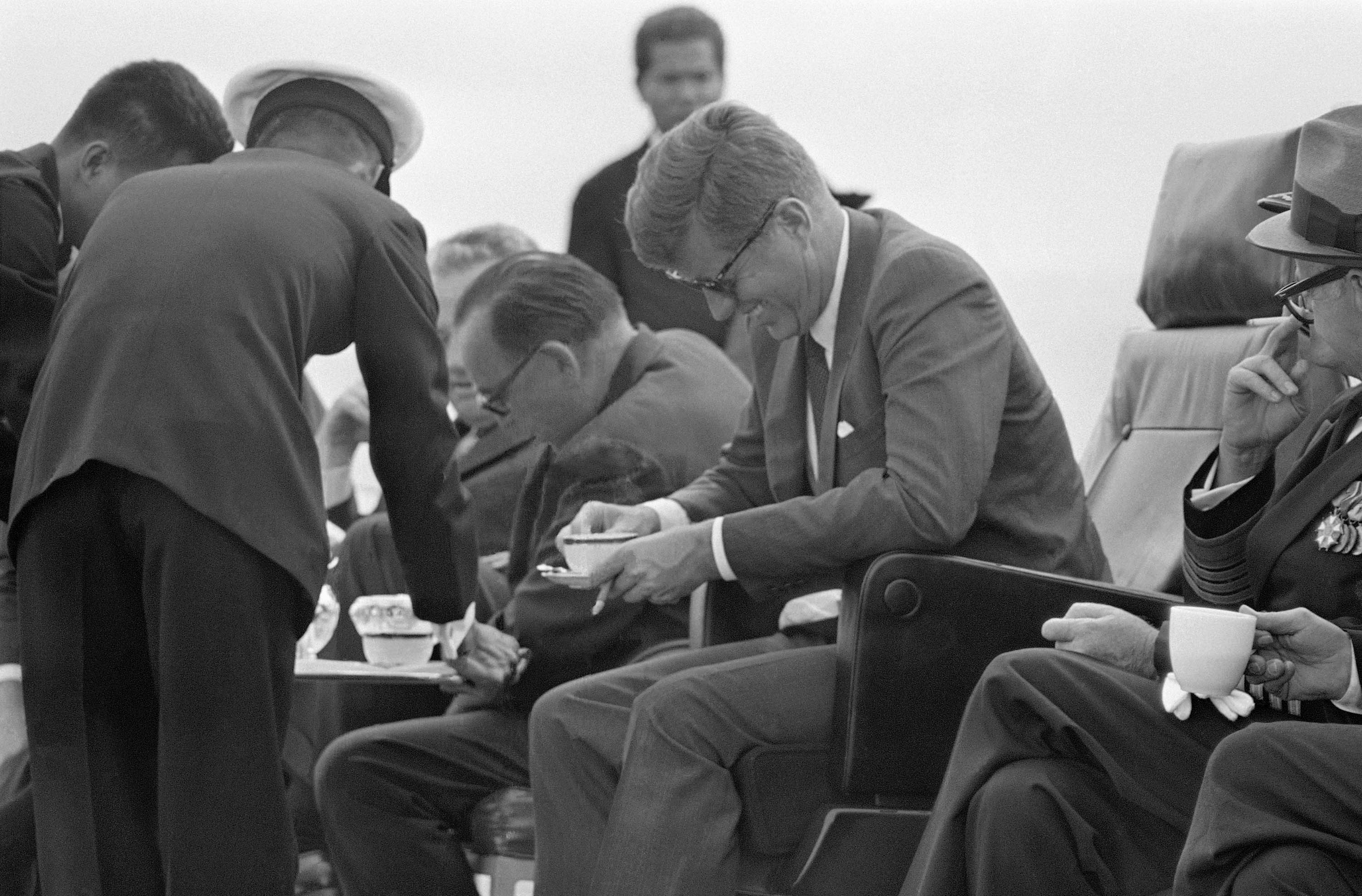 Gov. Edmund G. Brown let out a howl, to the amusement of President John F. Kennedy (right), after spilling a cup of coffee while watching special Navy maneuvers from the deck of the carrier Kitty Hawk.