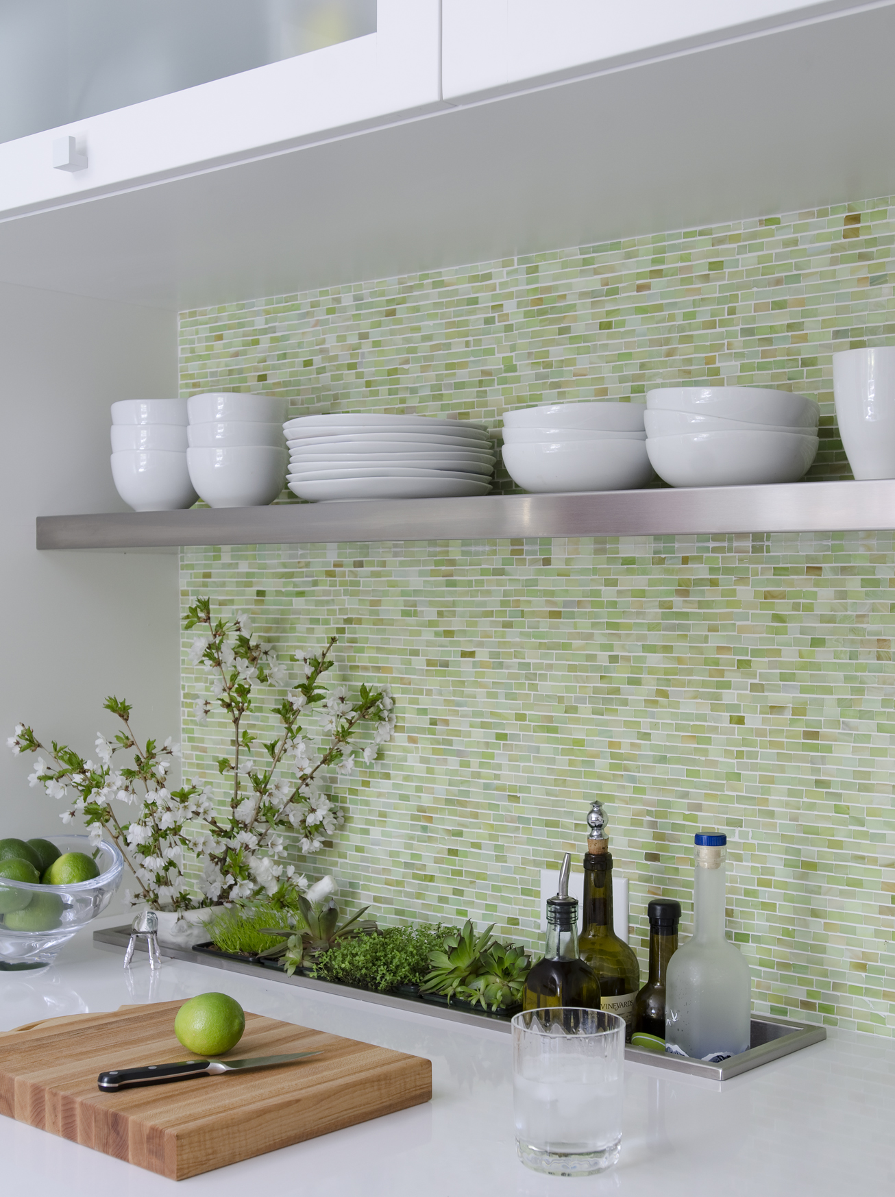 A trough dropped in the countertop holds wine and olive oil while the family’s everyday dishes rest on a stainless steel shelf. The Walter Zanger glass tiles were the first decorative element Swanson chose. “You can see this wall from the living room,” she says, “so it had to be beautiful.”