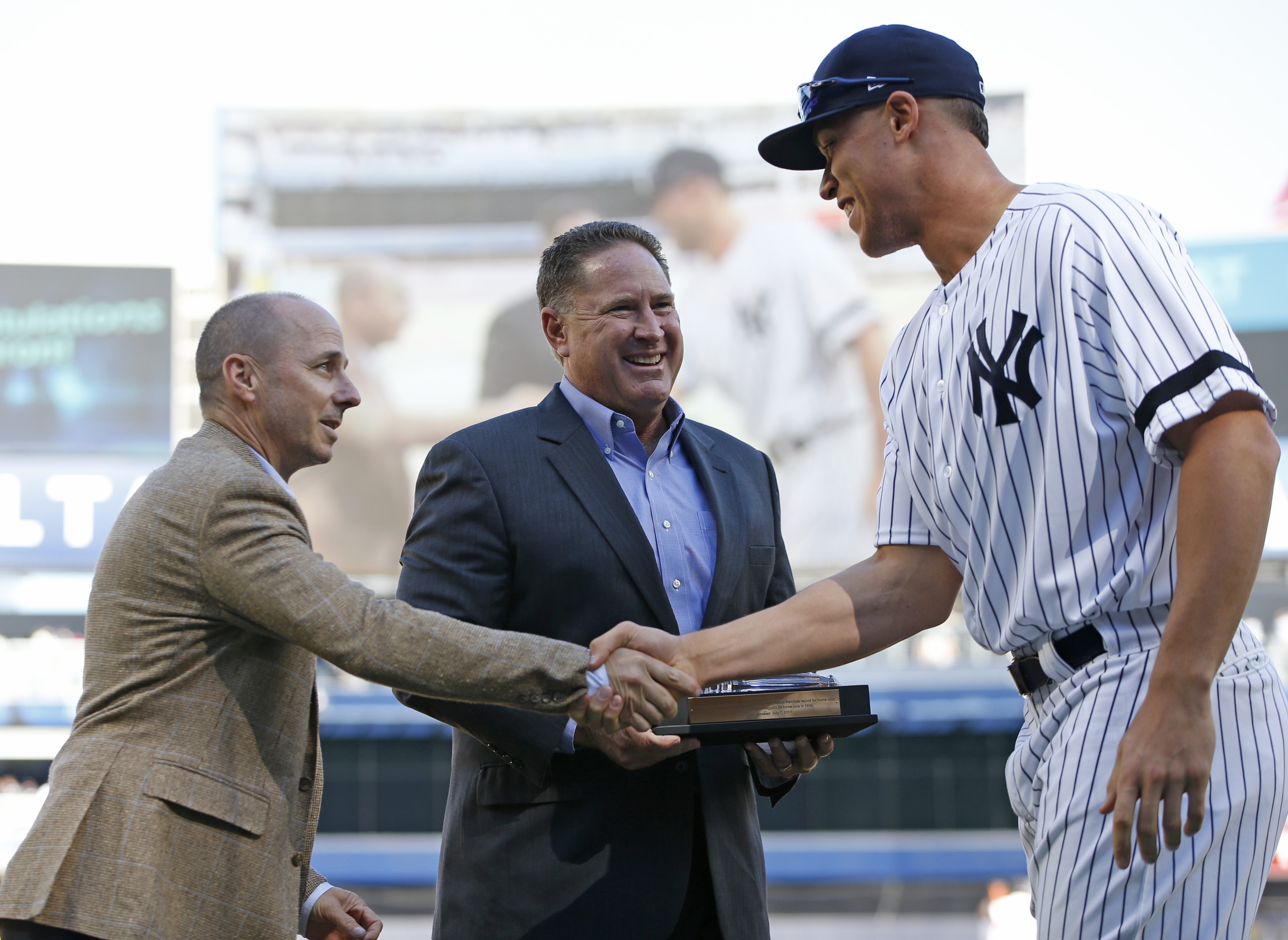 Brian Cashman (left) shook hands with Aaron Judge after presenting him with a crystal gavel for breaking the club’s rookie home-run record.