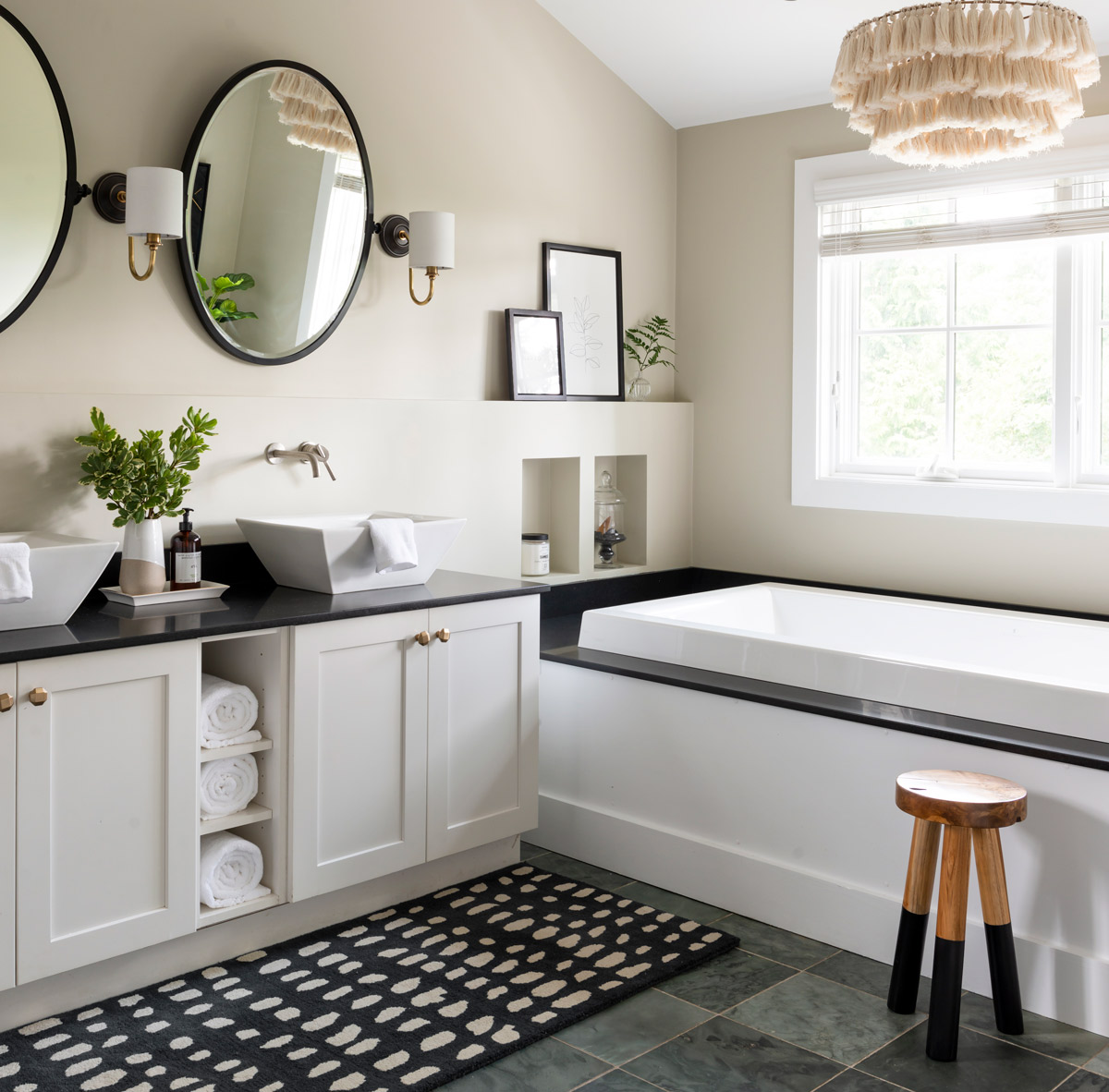 Burns updated the master bath with a fresh coat of white paint, a pair of round mirrors flanked by new sconces, and a fun light fixture.