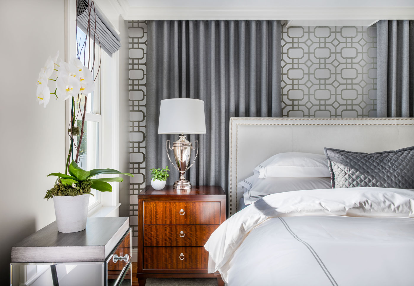 AFTER: Fulmer hung drapery panels behind the bed on two sides, even though only one covers a window. The geometric wallpaper is Portier Flock by Thibaut.