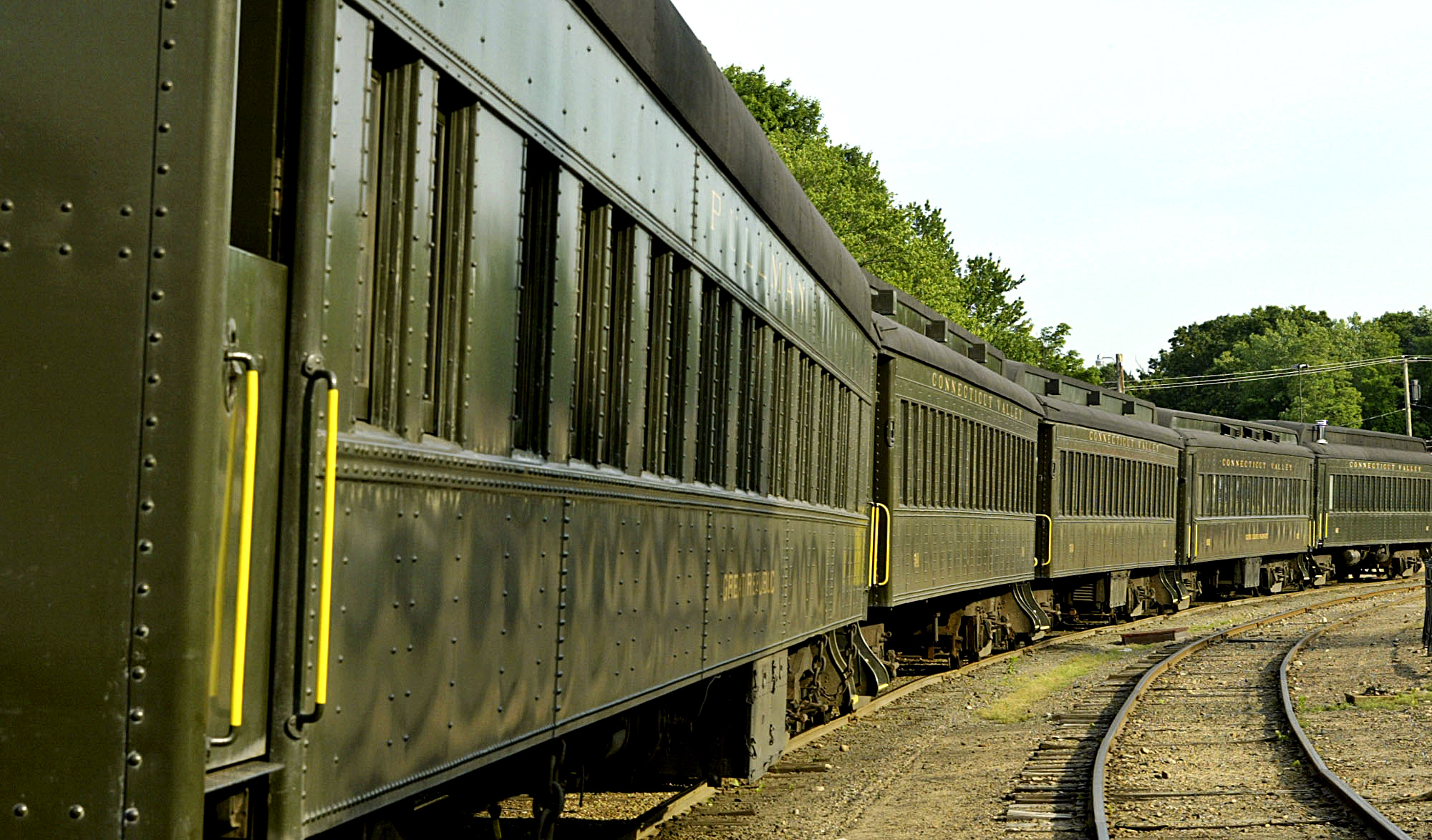 Restored coaches, used by the Essex Steam Train & Riverboat, line the tracks at the station.