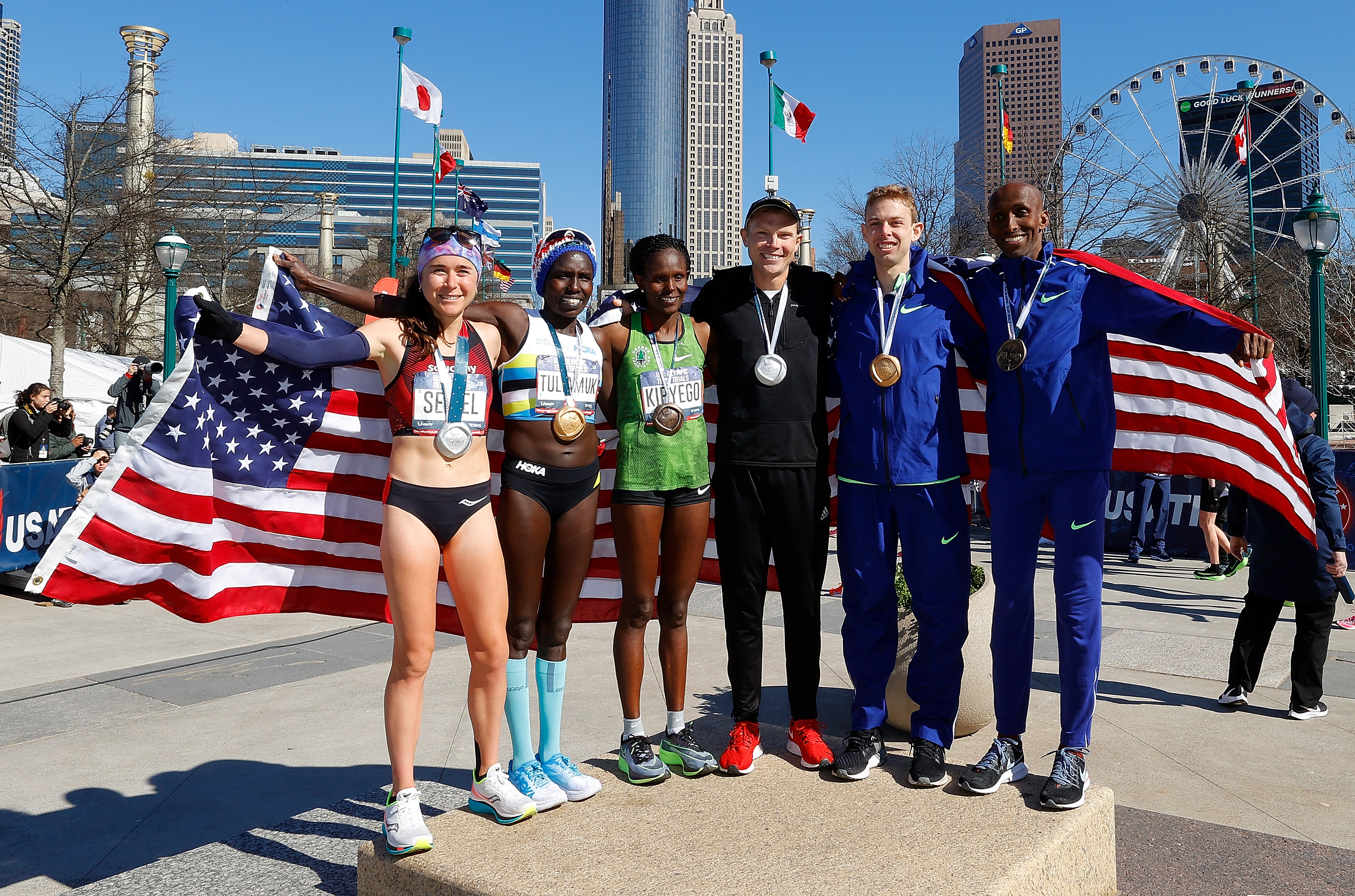 Molly Seidel, Aliphine Tuliamuk, Sally Kipyego, Jacob Riley, Galen Rupp, and Abdi Abdirahman (left to right) pose together after finishing in Saturday’s team trials.
