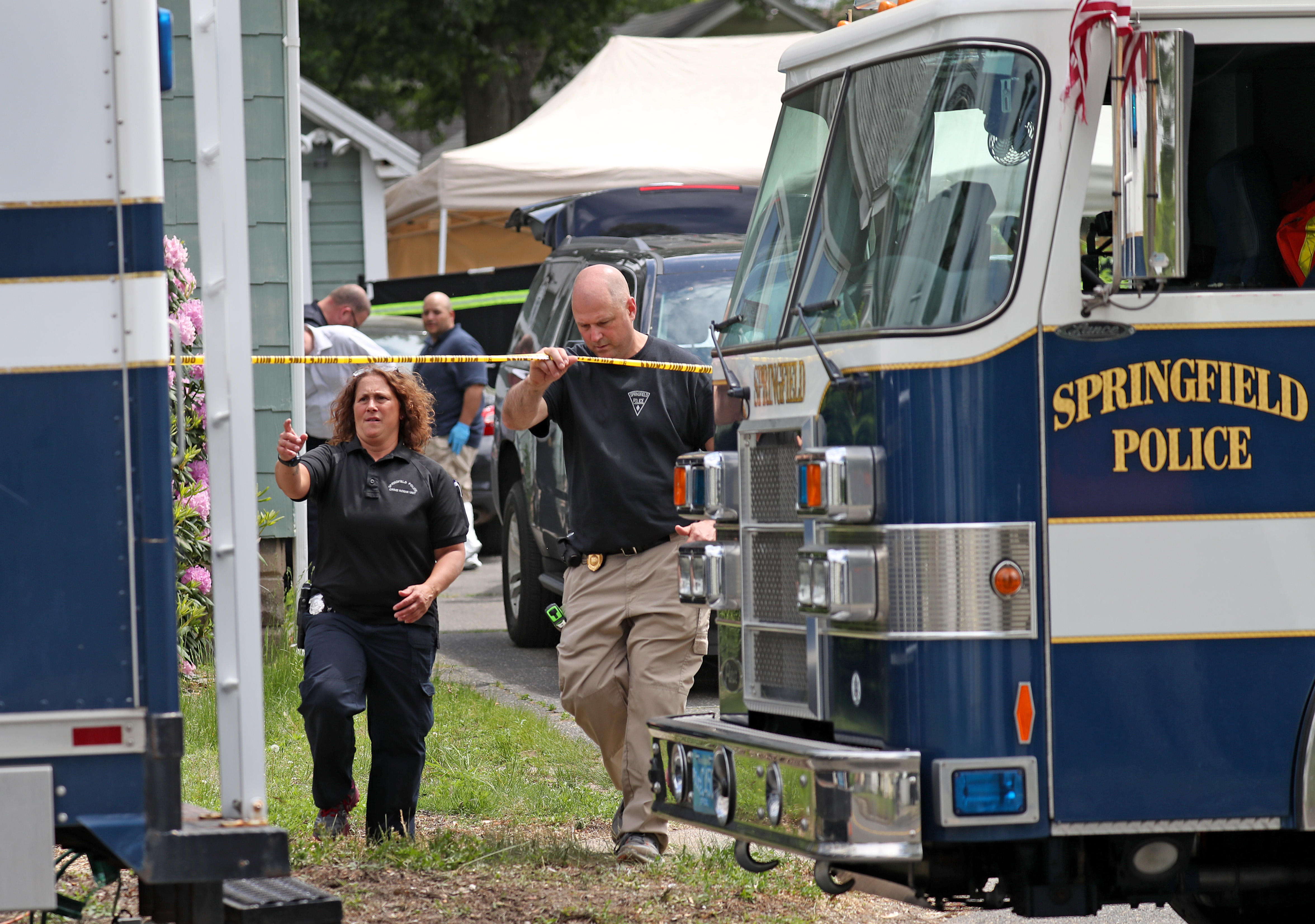 Police searched the yard of a Springfield home after discovering at least three bodies.