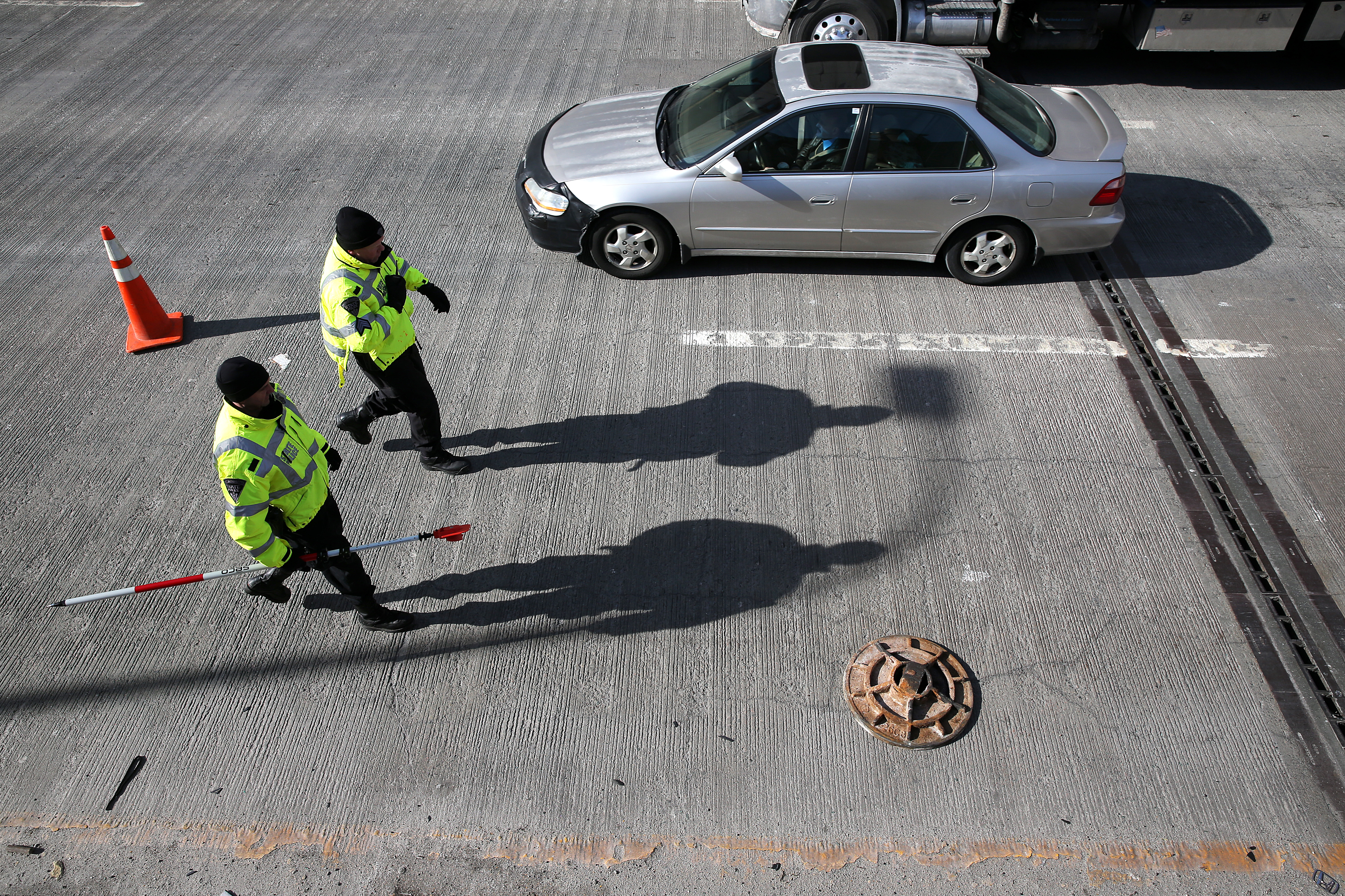 State Police walked past a manhole cover on I-93.