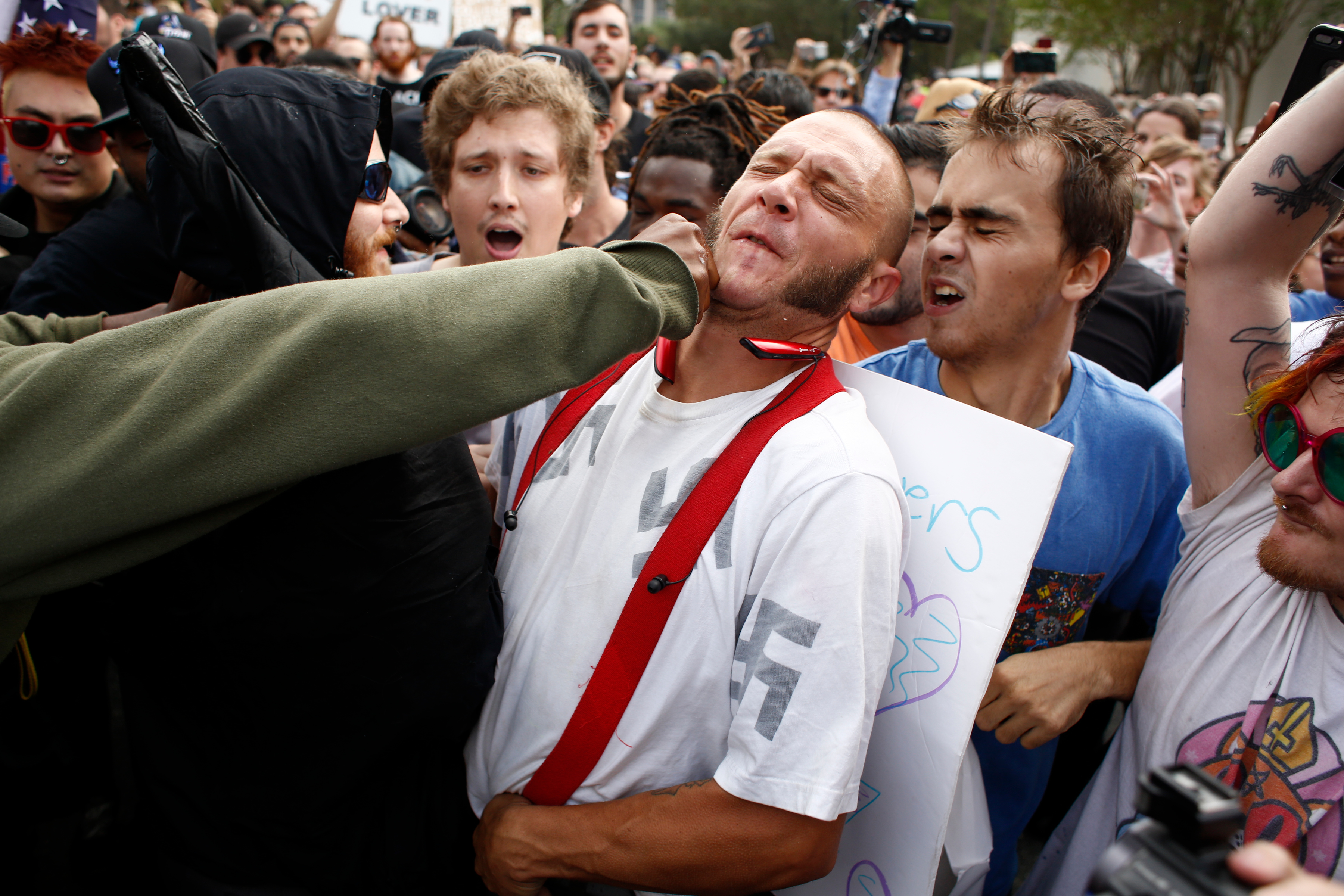 A man wearing a shirt with swastikas on it was punched by an unidentified member of the crowd near the site of a planned speech by white nationalist Richard Spencer.
