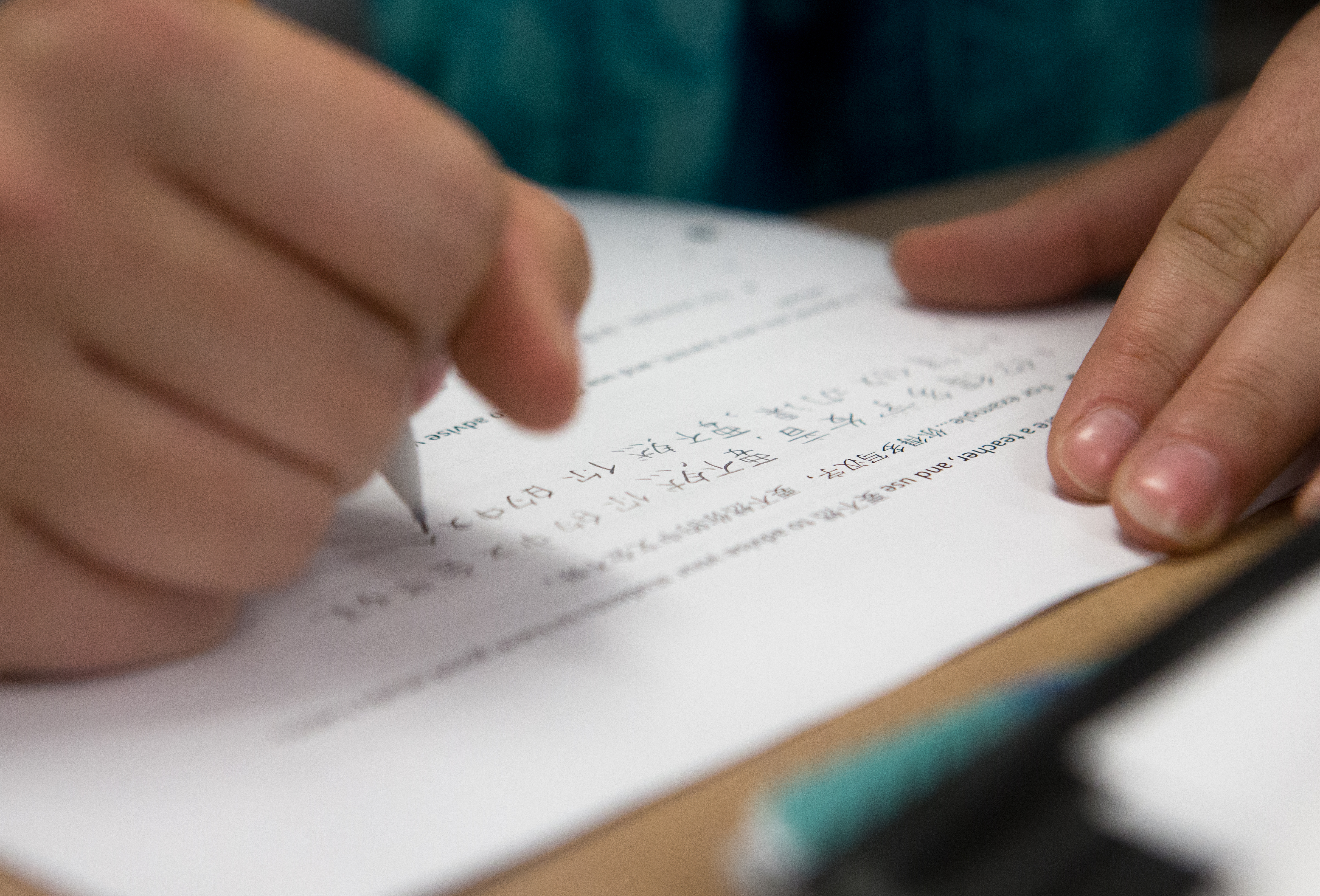 A student wrote Chinese characters on a packet during class at Hingham High School.