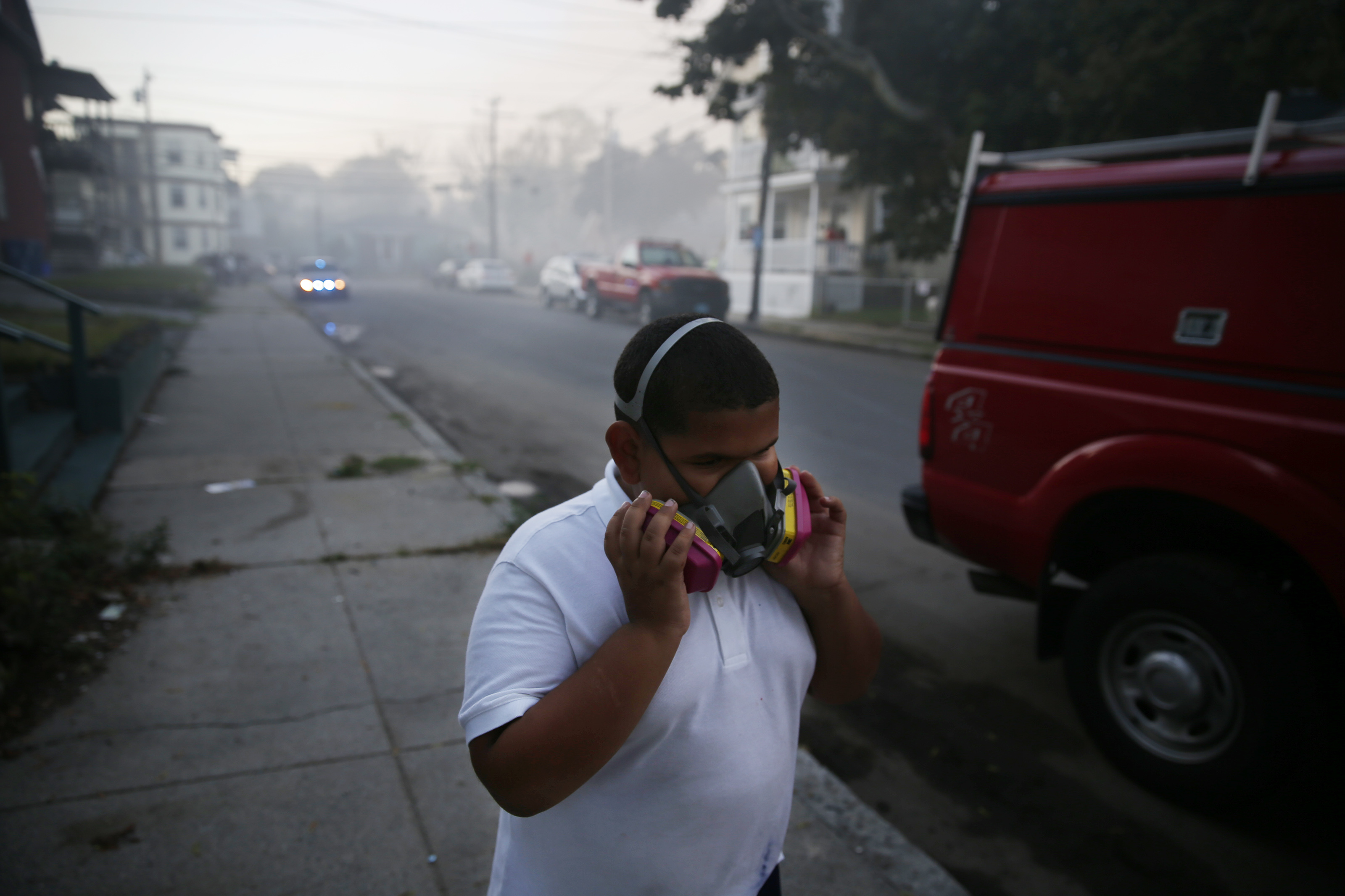 A boy used a mask to protect himself from heavy smoke from a fire on Bowdoin Street in Lawrence.