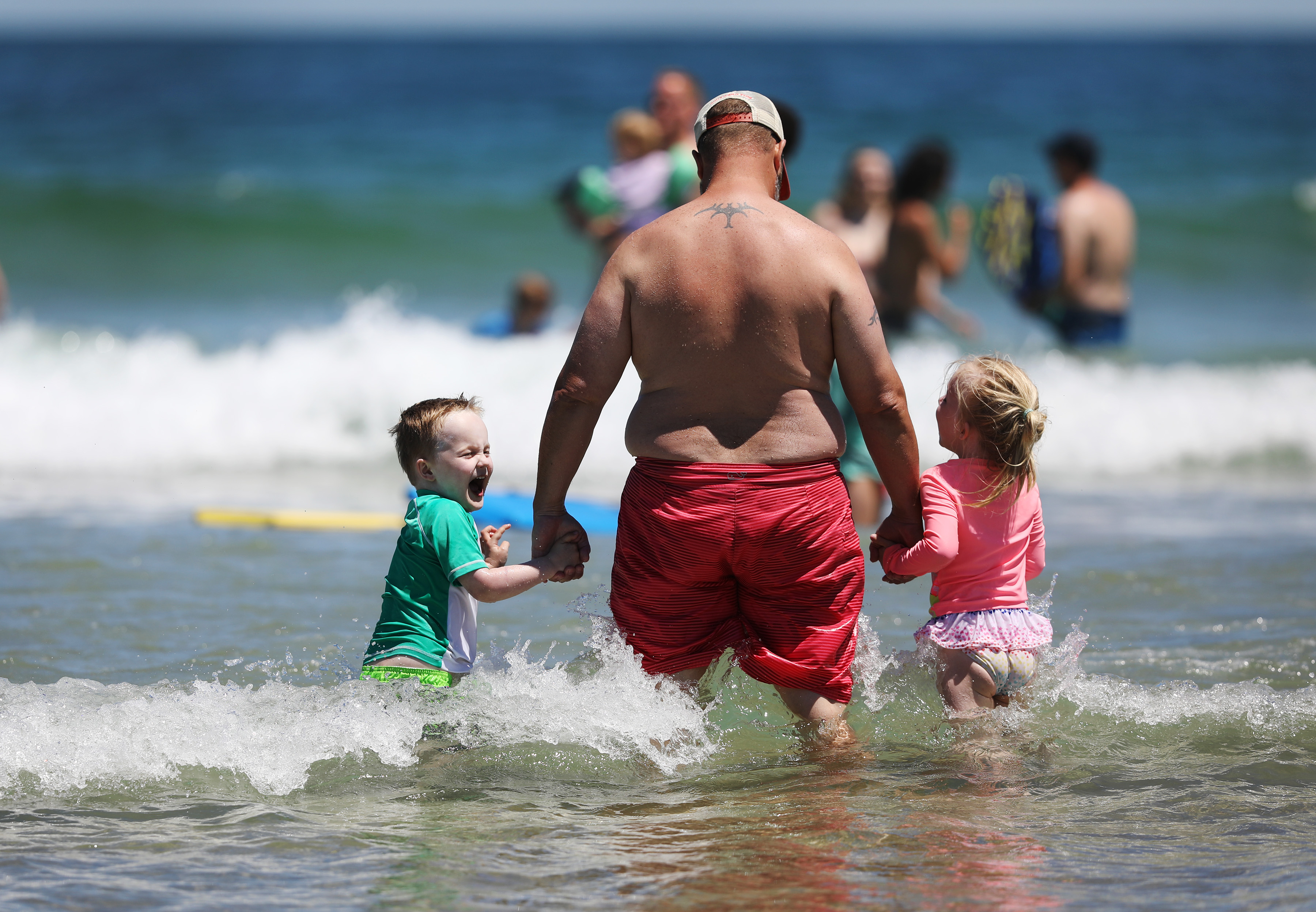 David Caillouette waded in the ocean with his twins, Aidan (left) and Madeline, 5, in Orleans.