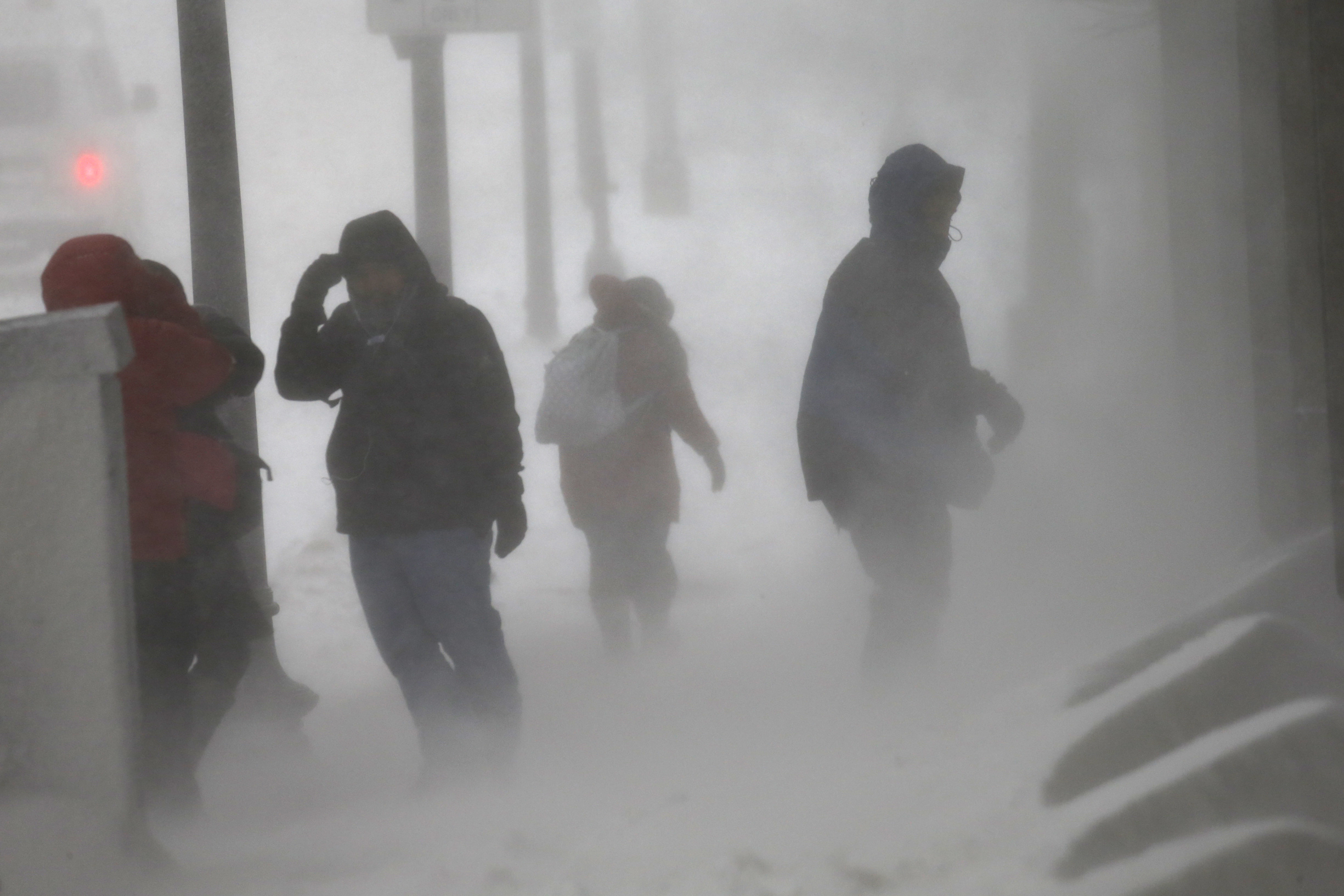 Pedestrians struggled in high winds and snow on Congress Street in downtown Boston.