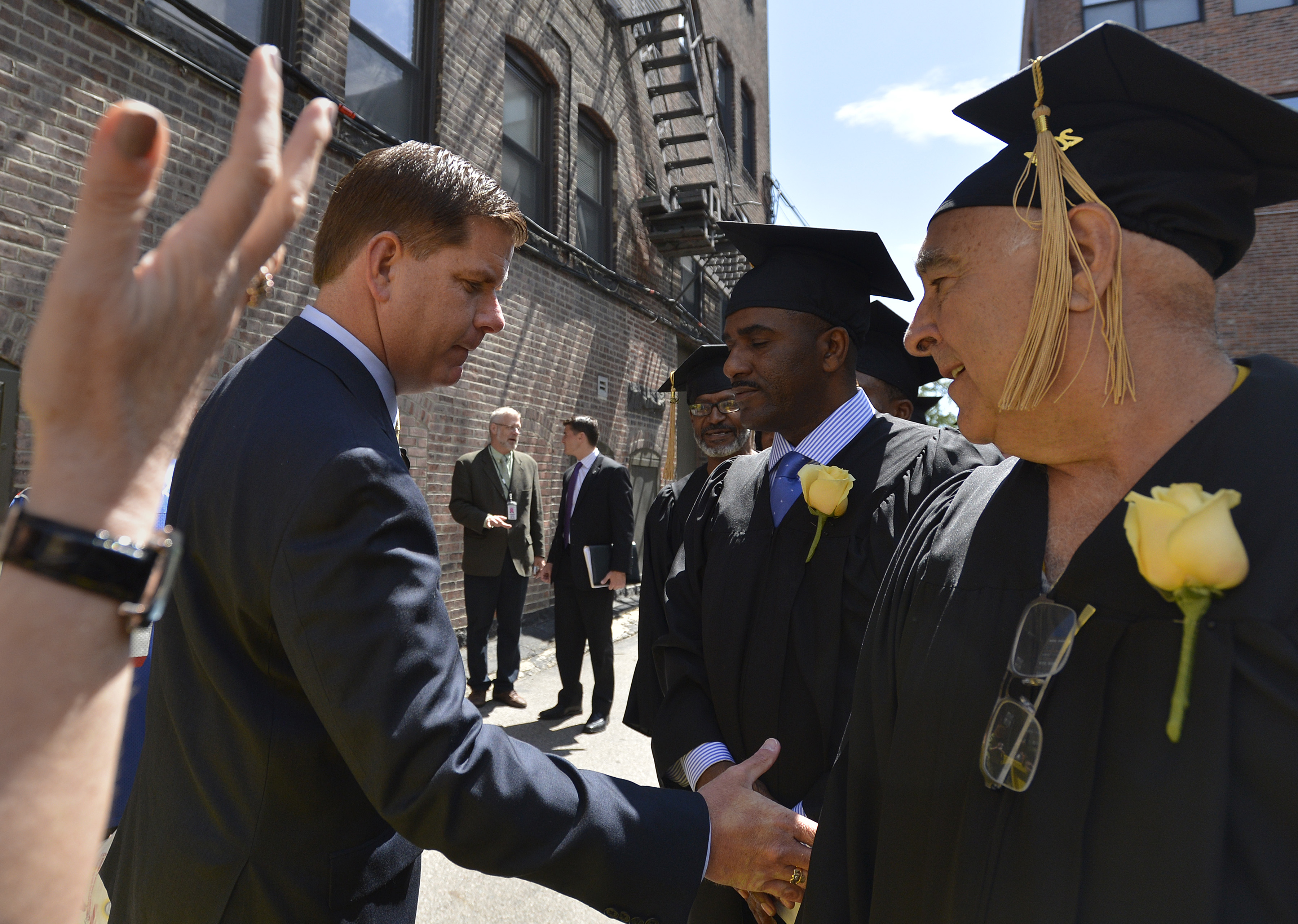 Mayor Martin J. Walsh shook the hand of Sam Bernard (right) as he made his way down the line of graduates at the Pine Street Inn homeless shelter Wednesday.