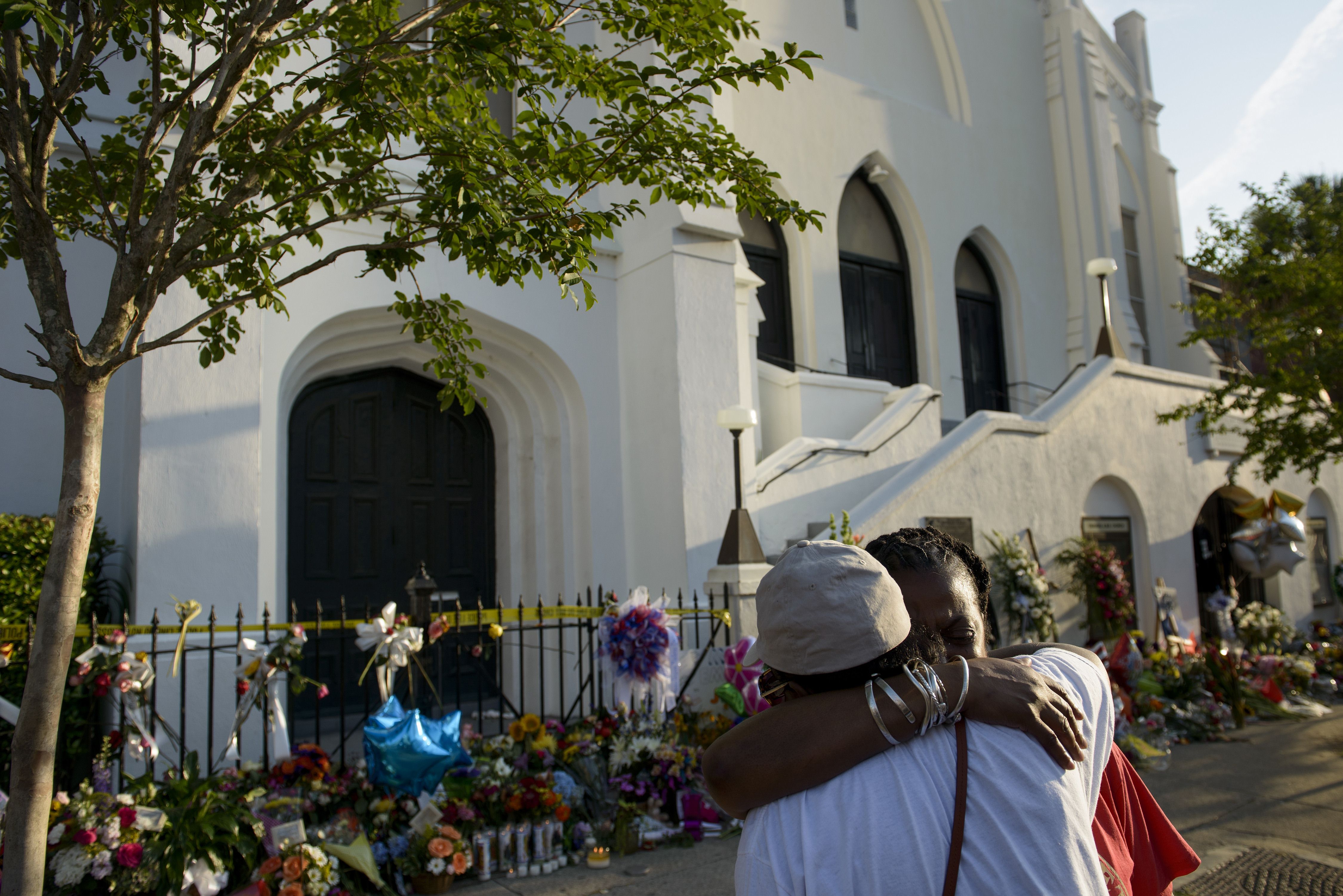 Cynthia Wright-Murphy (left) hugs her sister Carolyn Wright-Porcher outside the Emanuel African Methodist Episcopal Church Saturday.