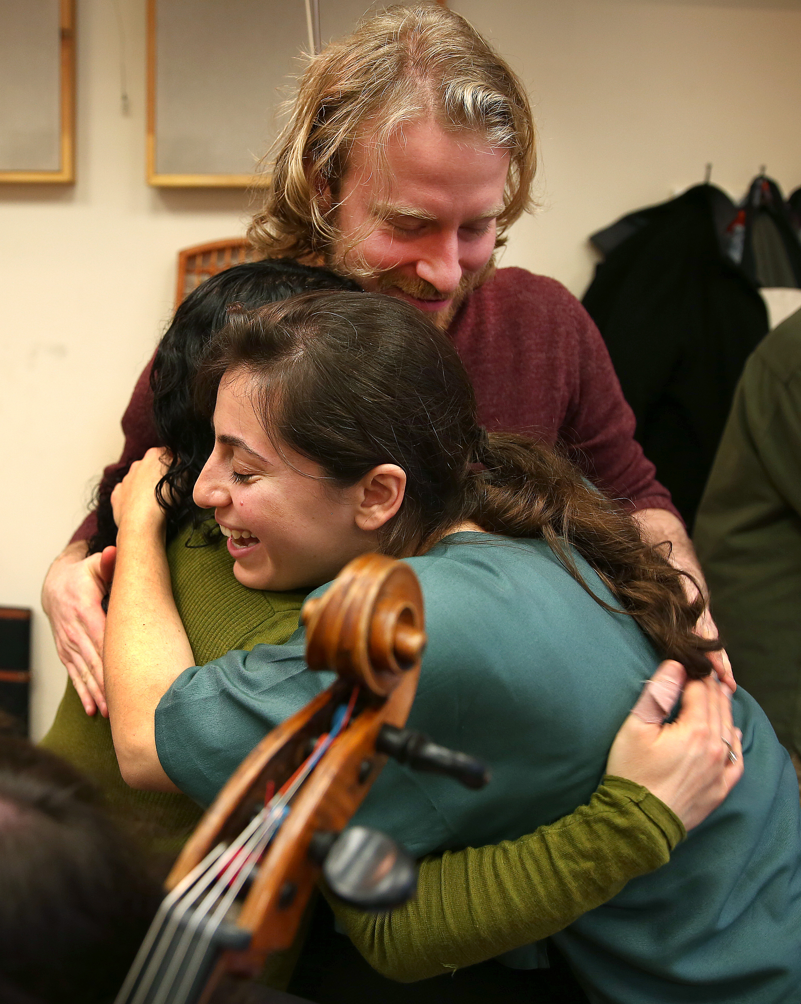 Karen Ouzounian (right) hugs Annie Rabbat and Erik Higgins.
