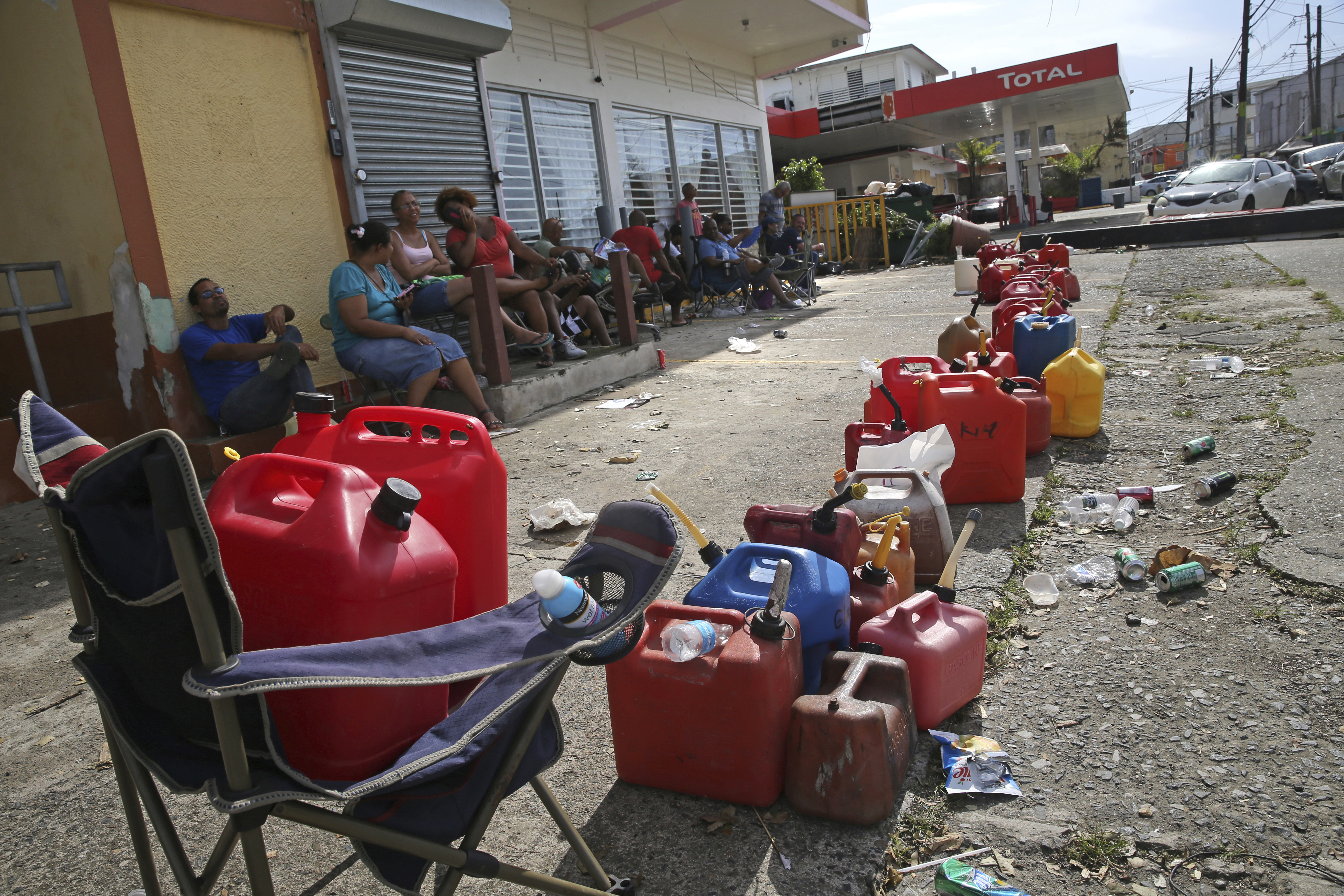 Residents lined up gas cans as they waited for a gas truck to service an empty gas station.