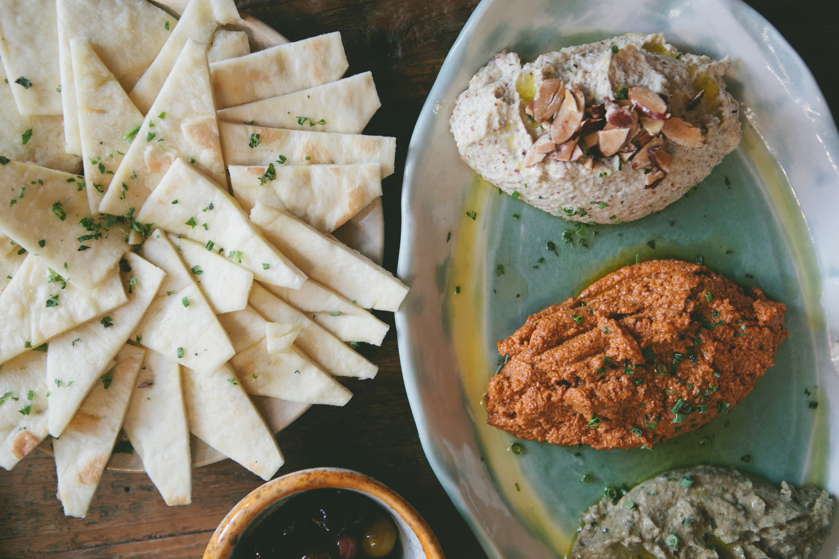 Becker’s line of signature dips and spreads includes Middle Eastern flavors such as hummus, smoked eggplant, and tzatziki (top).