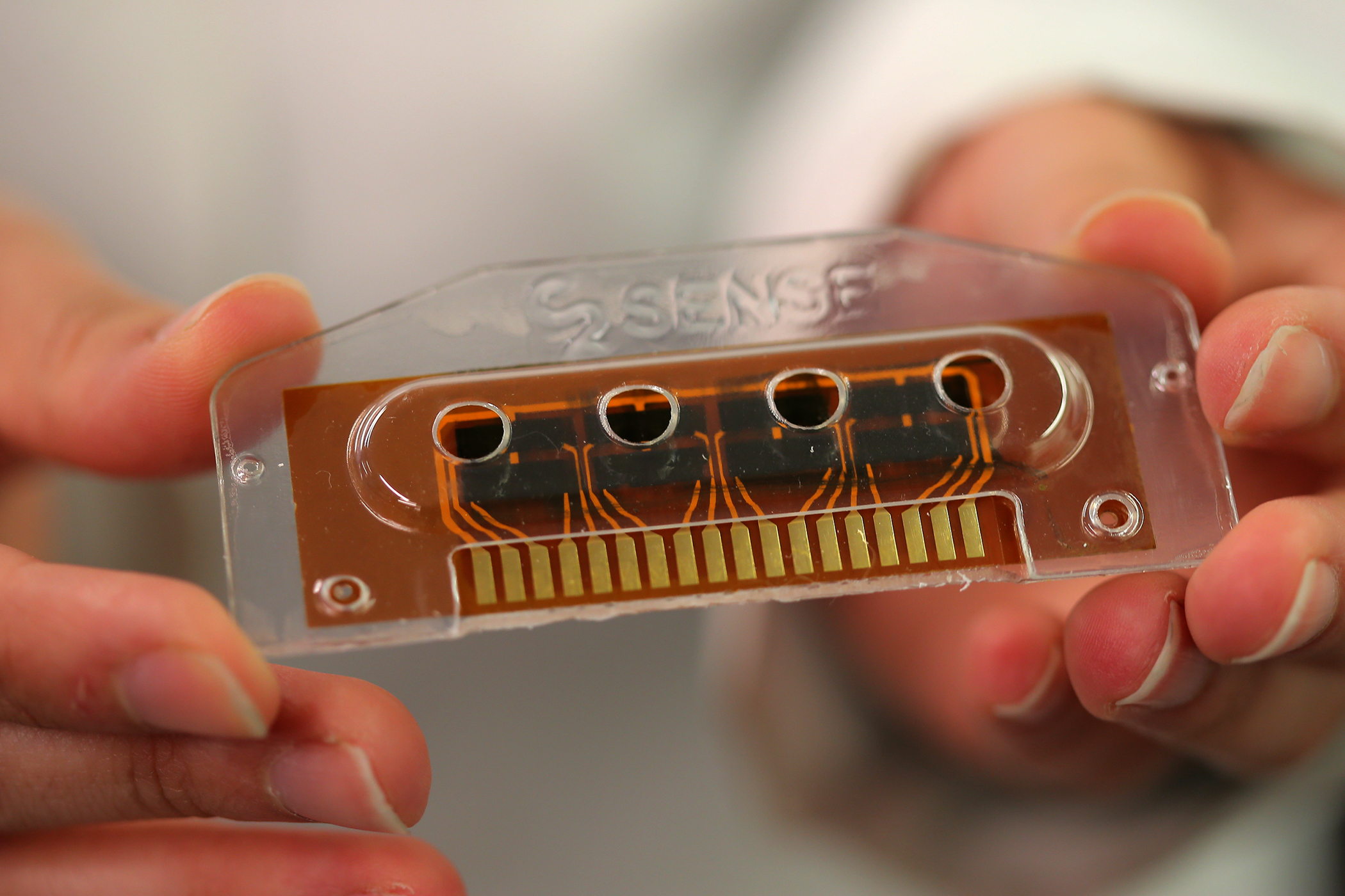 A scientist at C2Sense in Cambridge held an interchangeable insert, the core of the sensing ability of the company's new technology.