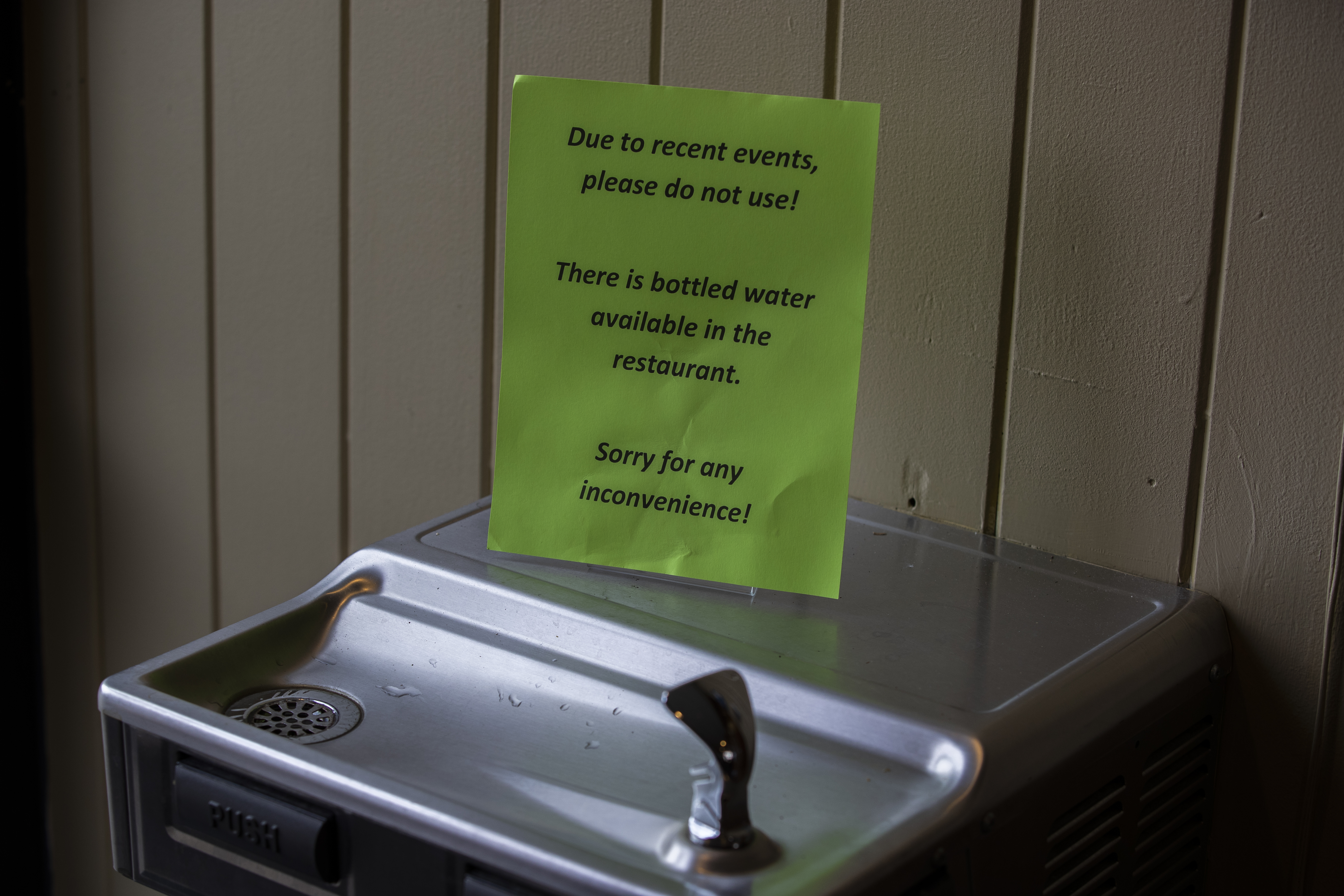 A sign warned patrons to avoid using a shared water fountain.