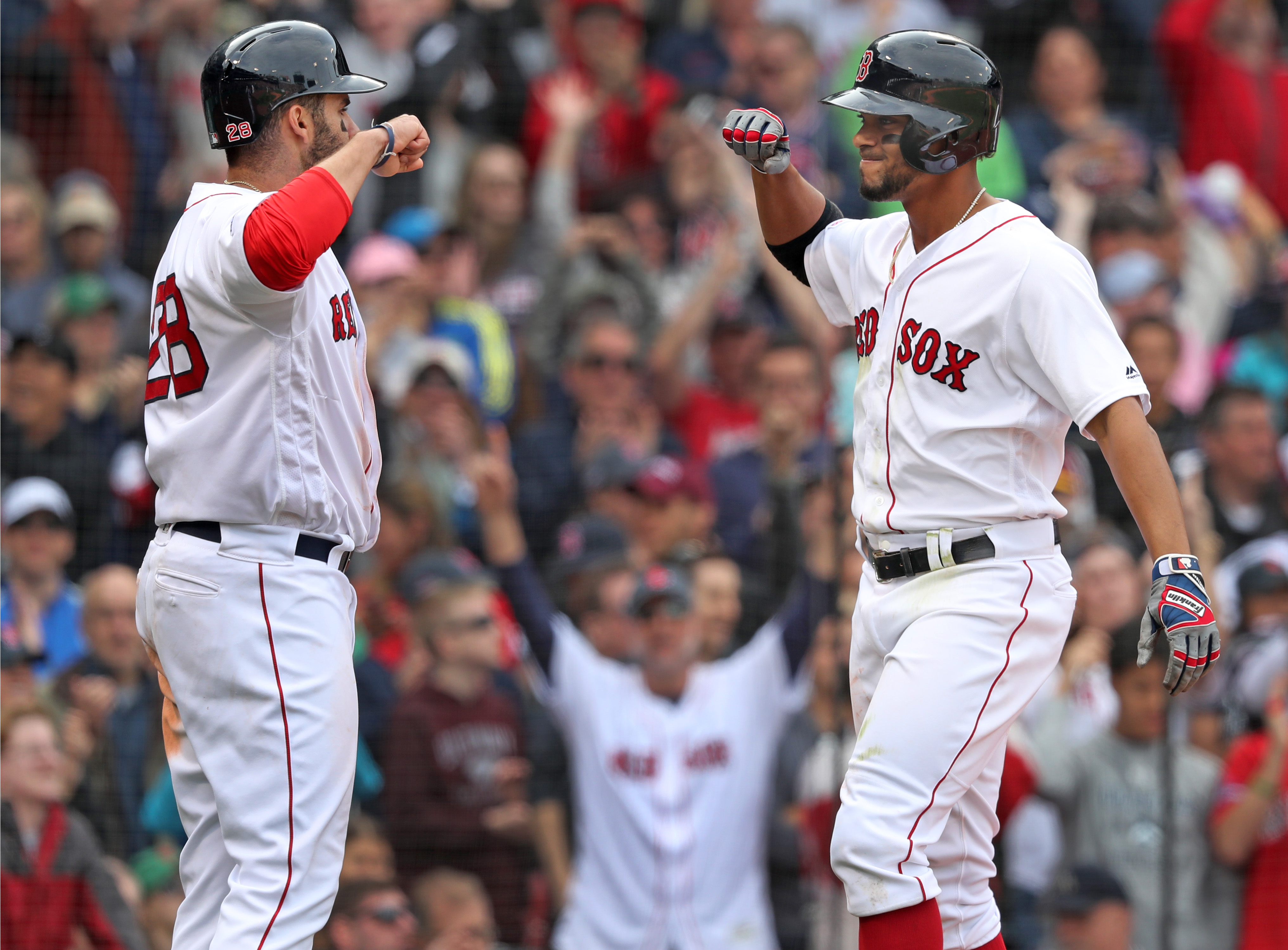 Xander Bogaerts (right) had the fans on their feet as he crossed the plate and fist bumped with teammate J.D. Martinez following his bottom of the eighth inning three-run home run.