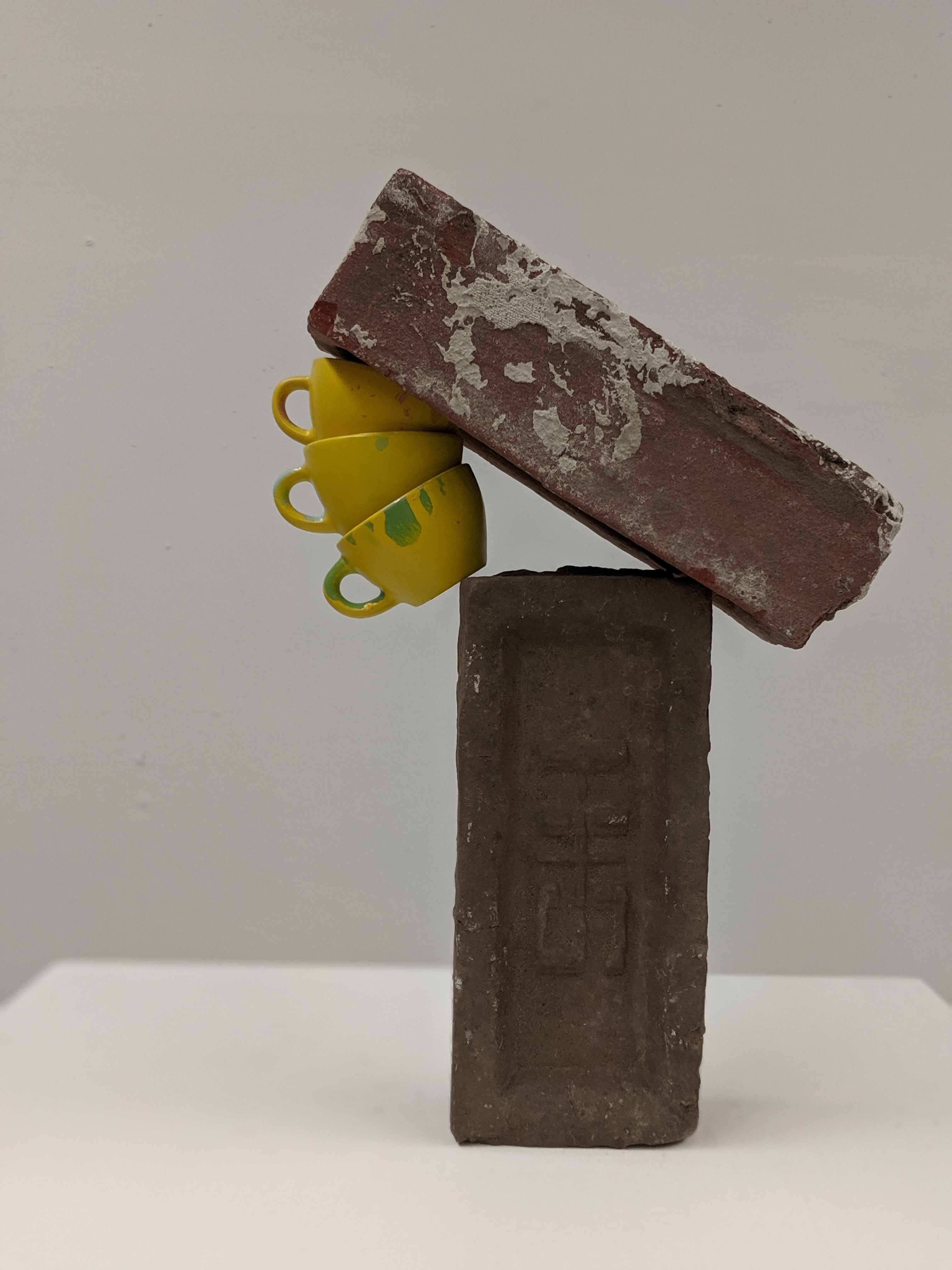 Nate Heilman made sculptures wedging fragile cups among rugged bricks. “The teacups pop out sometimes,” he said.