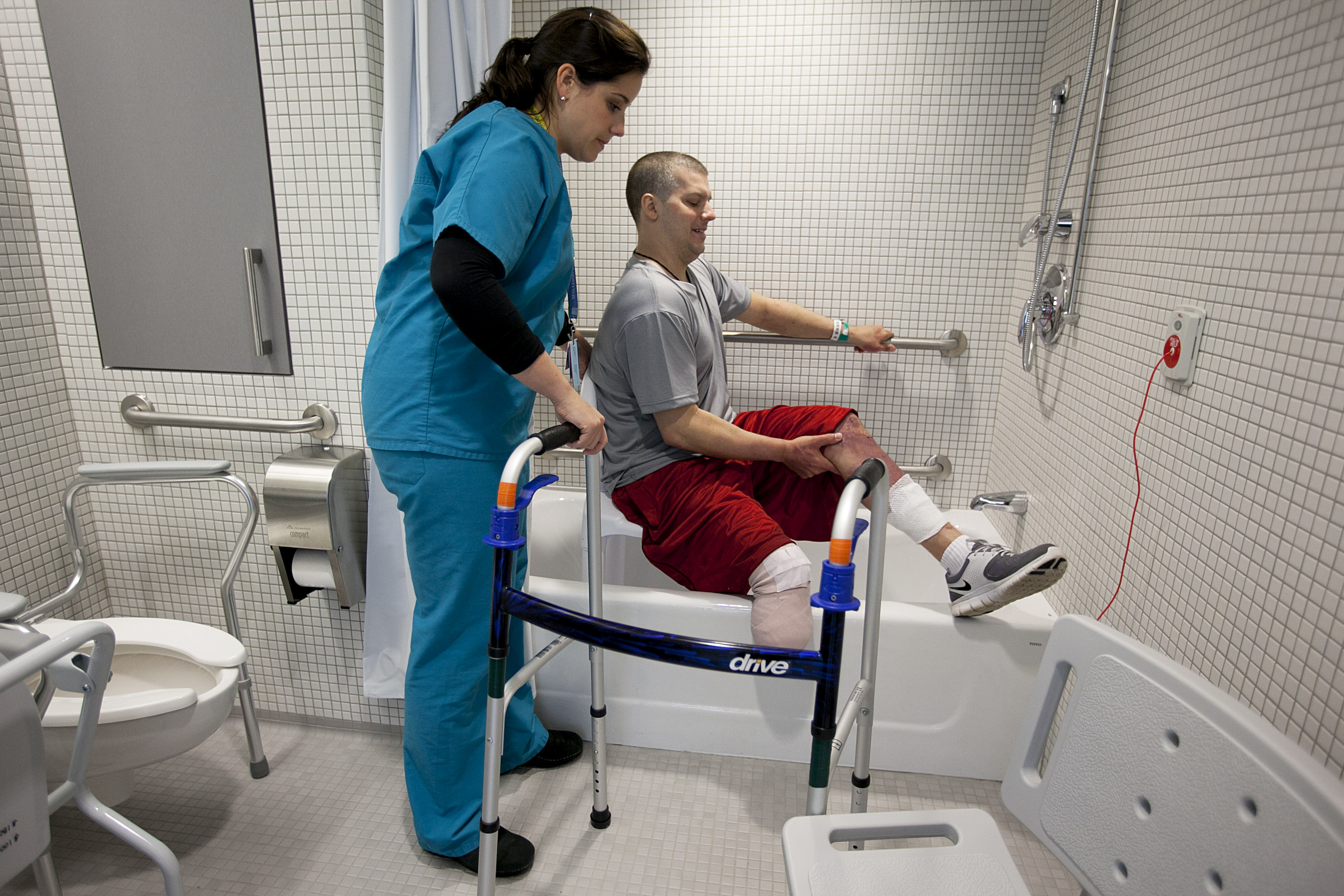 Occupational therapist Marissa Osborne helped Marathon bombing victim J.P. Norden of Stoneham practice getting in and out of the bathtub with a seat.