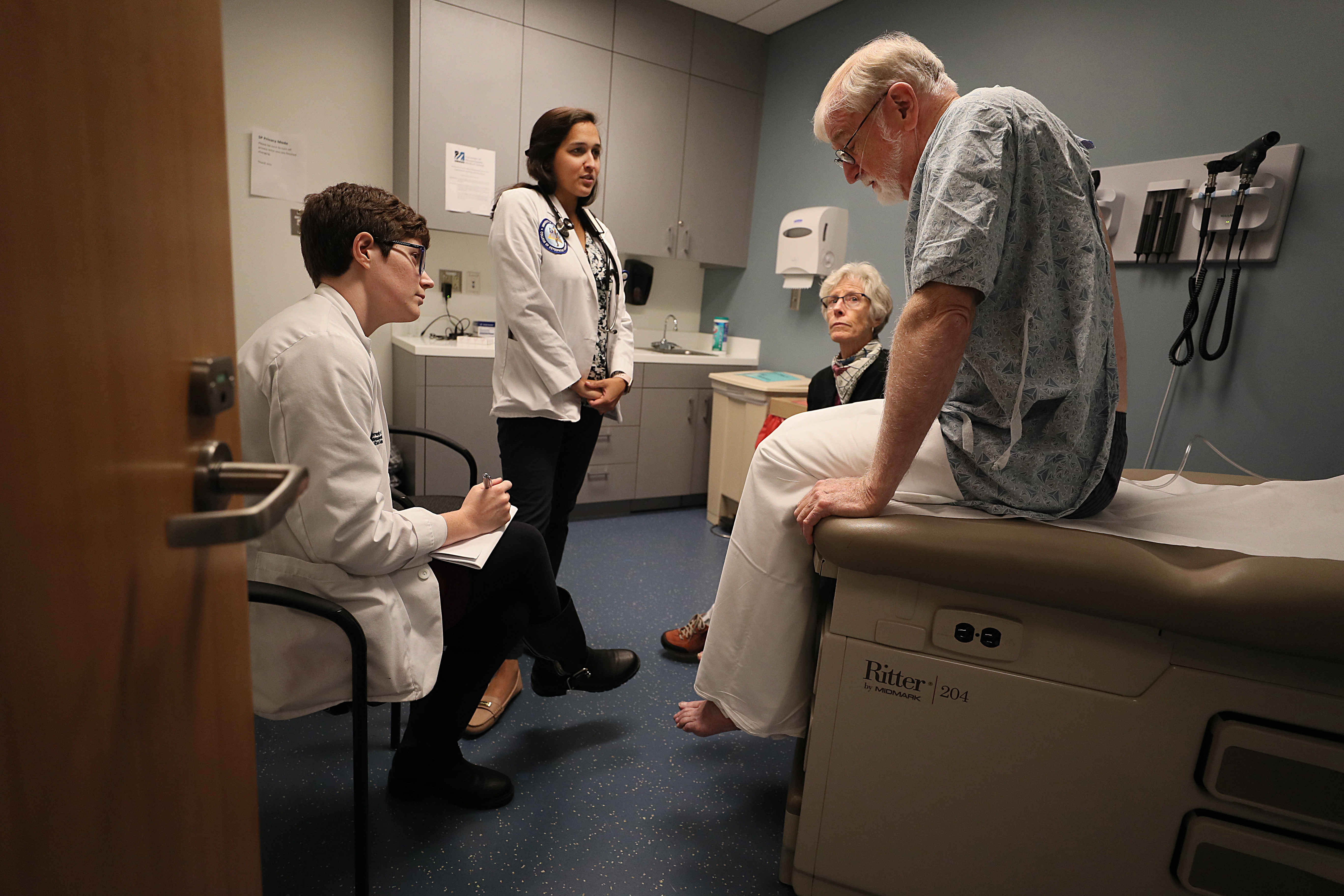 UMass Medical School students Stephanie Bond and Neiha Kidwai conferred with actors (Jackson Royal and Lisa Piehler) portraying a dying man and his wife.
