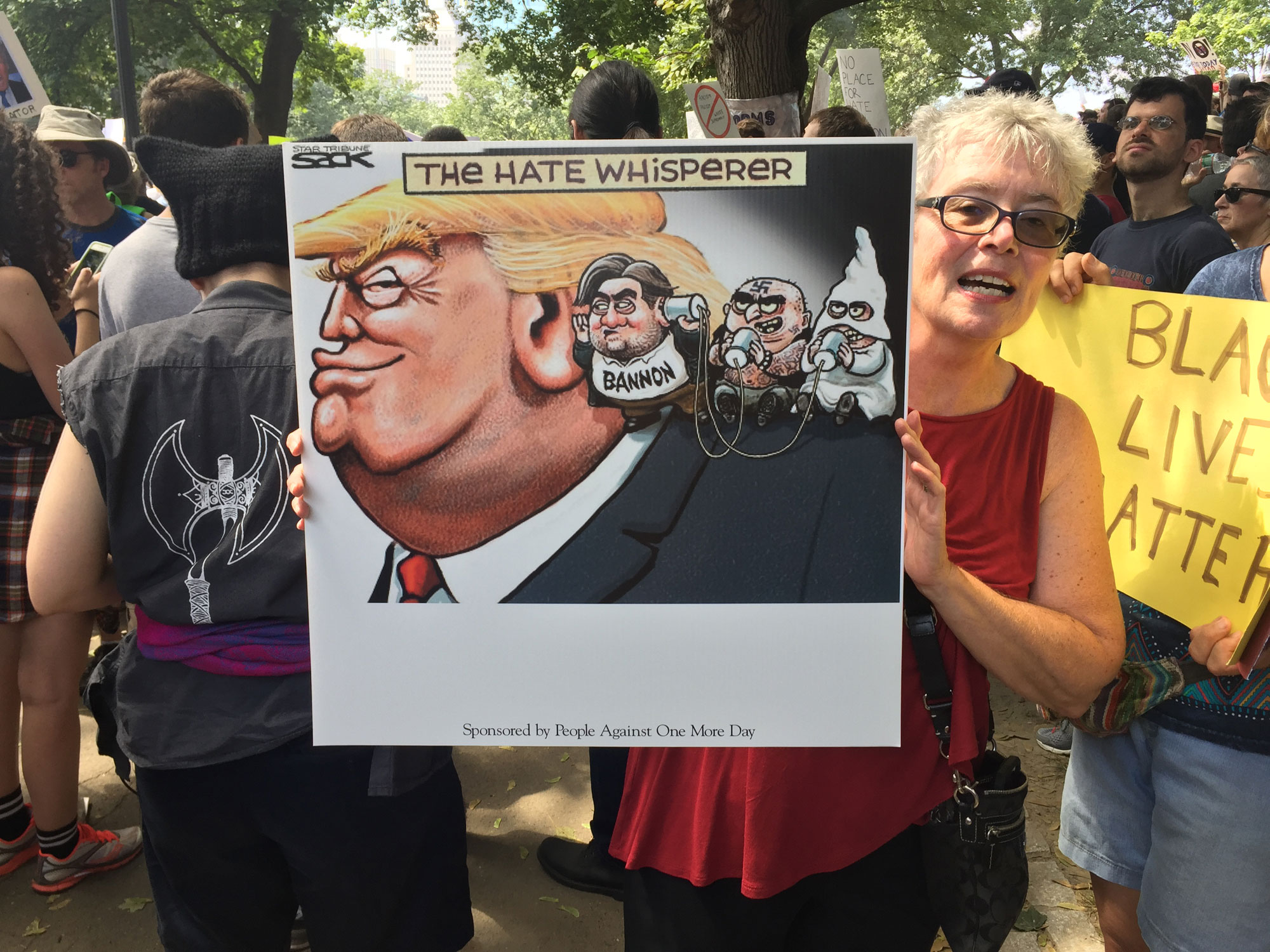 A woman held up a sign about President Donald Trump.