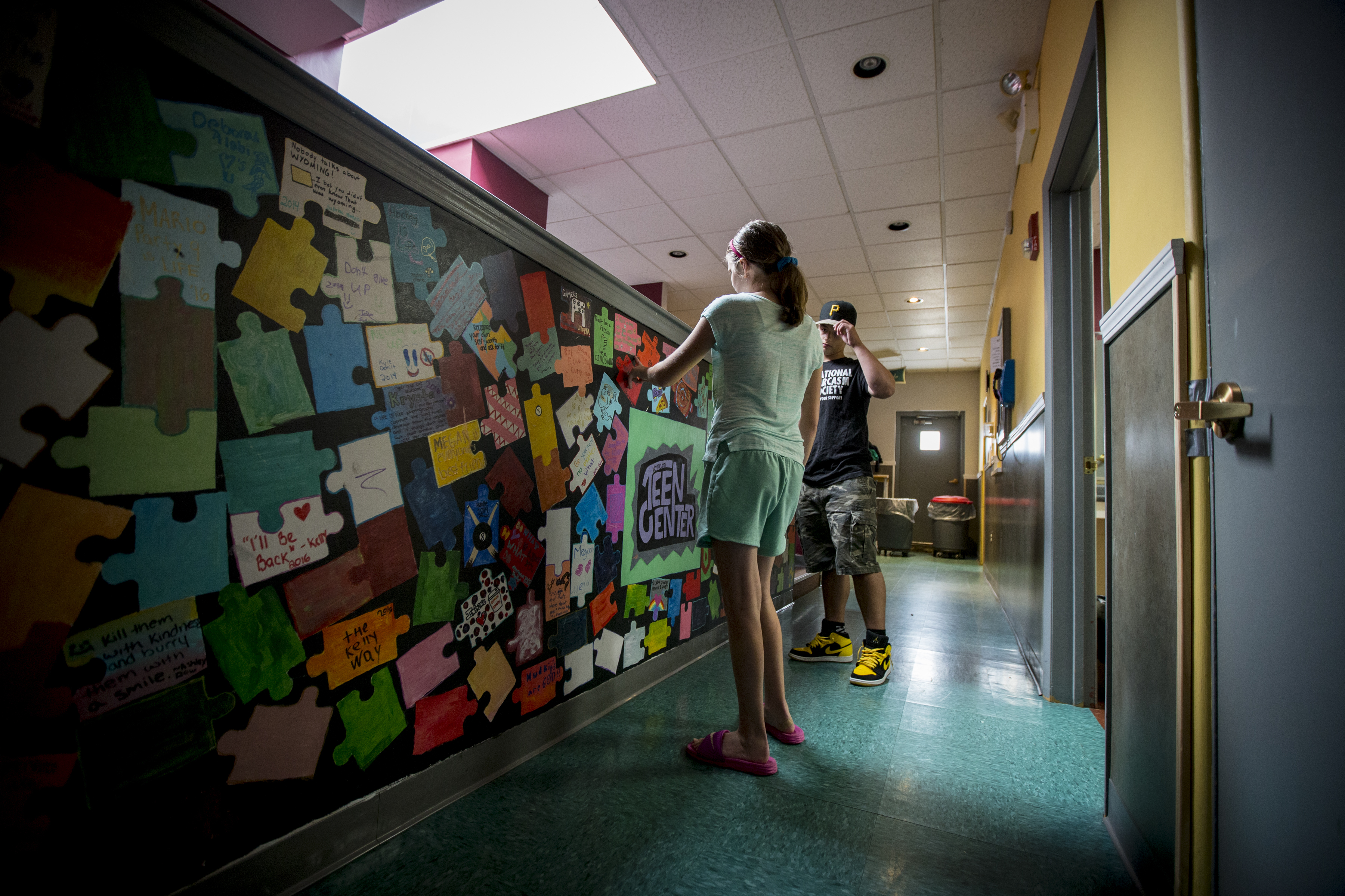 Melanie Nee, 13 and Marco Pizzi, 15, near a puzzle wall at the Weymouth Teen Center.