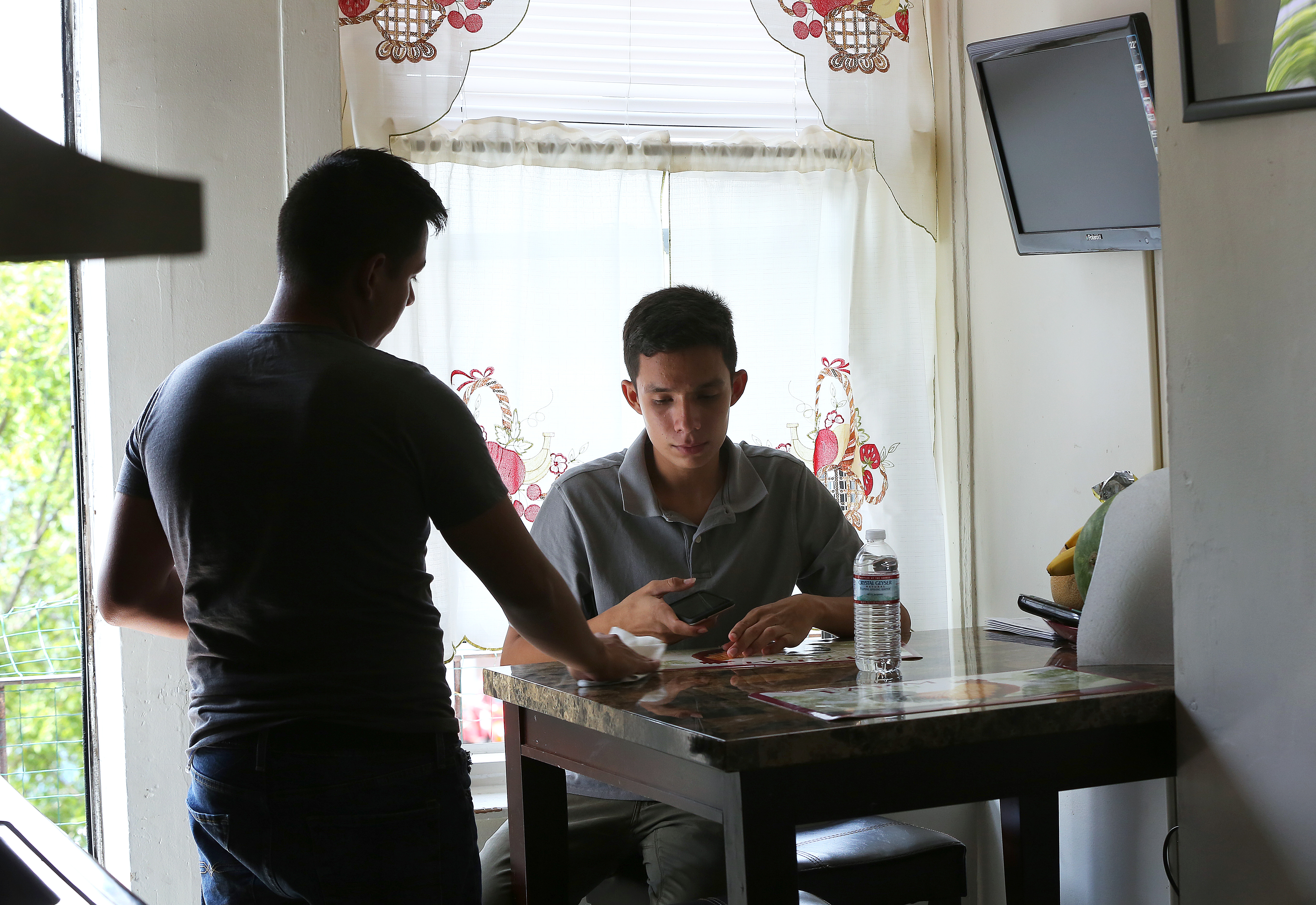 Jorge Diaz Savala, 17, (left) and his brother, Cesar Diaz Savala, 15, were separated from their father after authorities discovered the family lost in the desert along the Arizona border. They had fled El Salvador, where they say gangs threatened to kill the entire family over their father’s political activities. The brothers are staying in their uncle’s small apartment in Brighton.